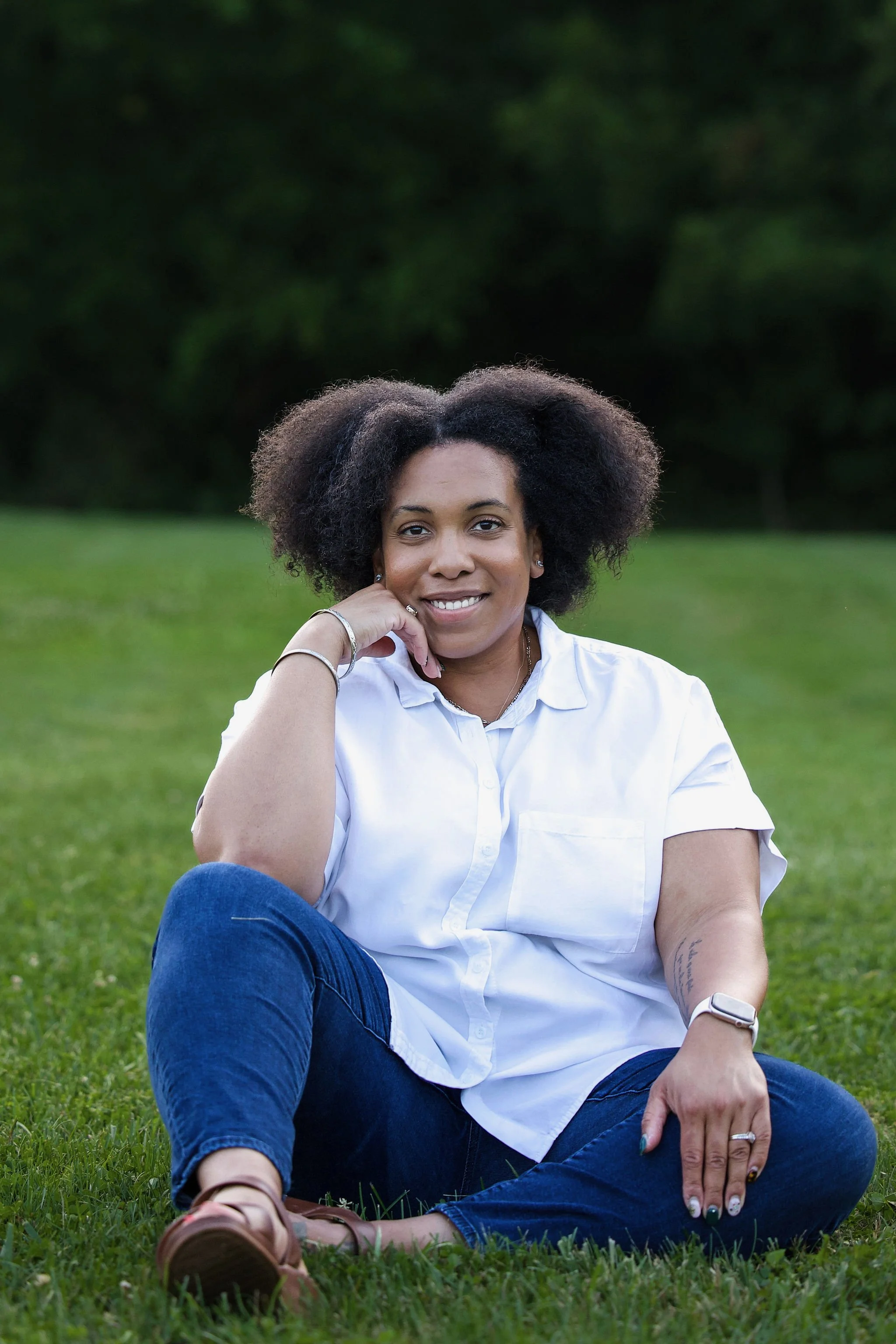 an African American woman sitting and smiling into the camera