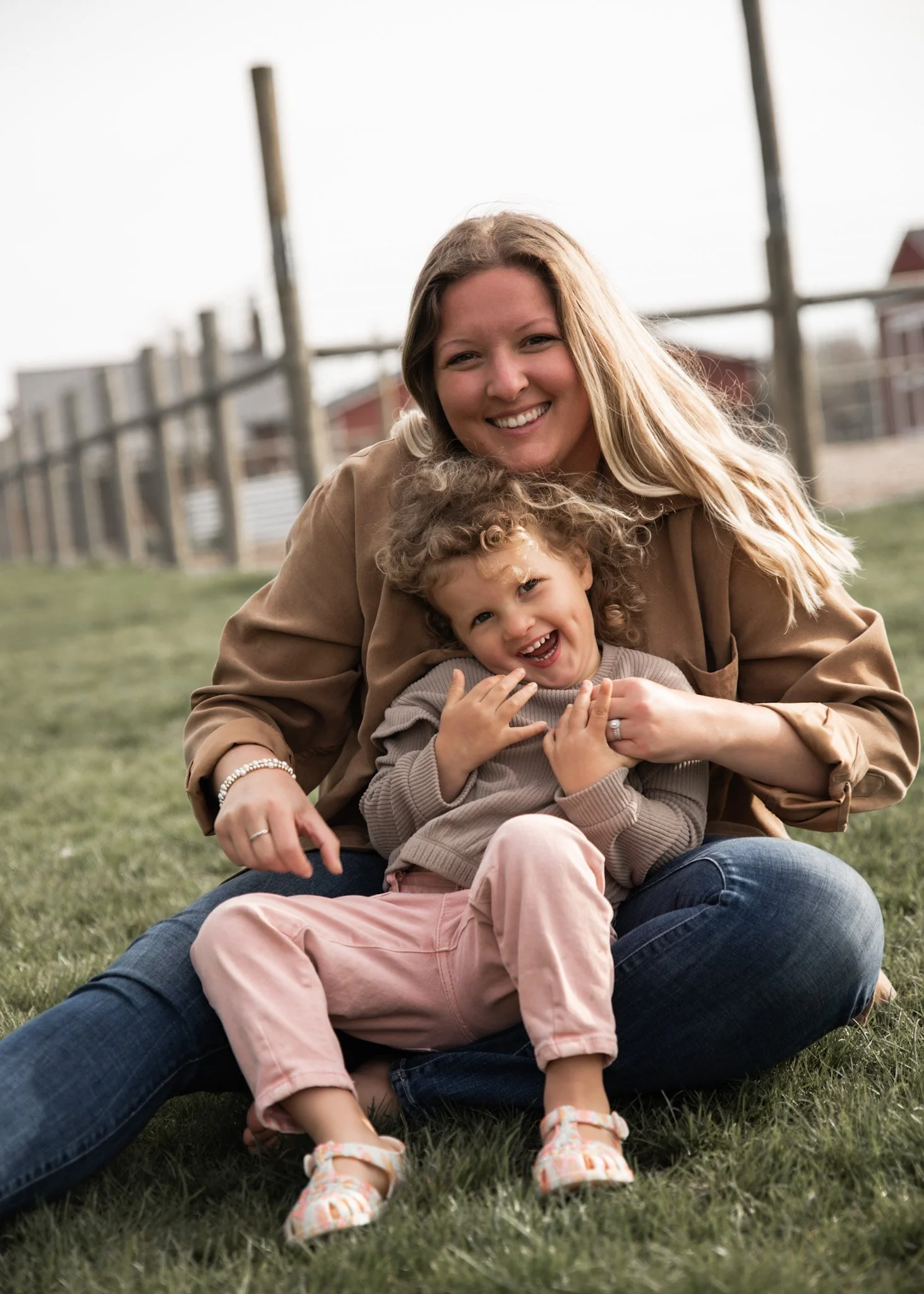 a blonde haired woman holding her daughter and laughing
