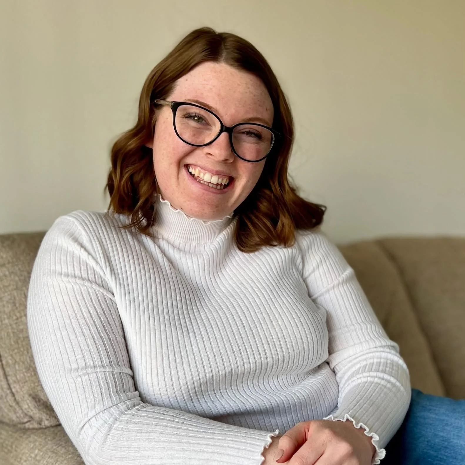 an image of a woman wearing glasses and smiling into the camera