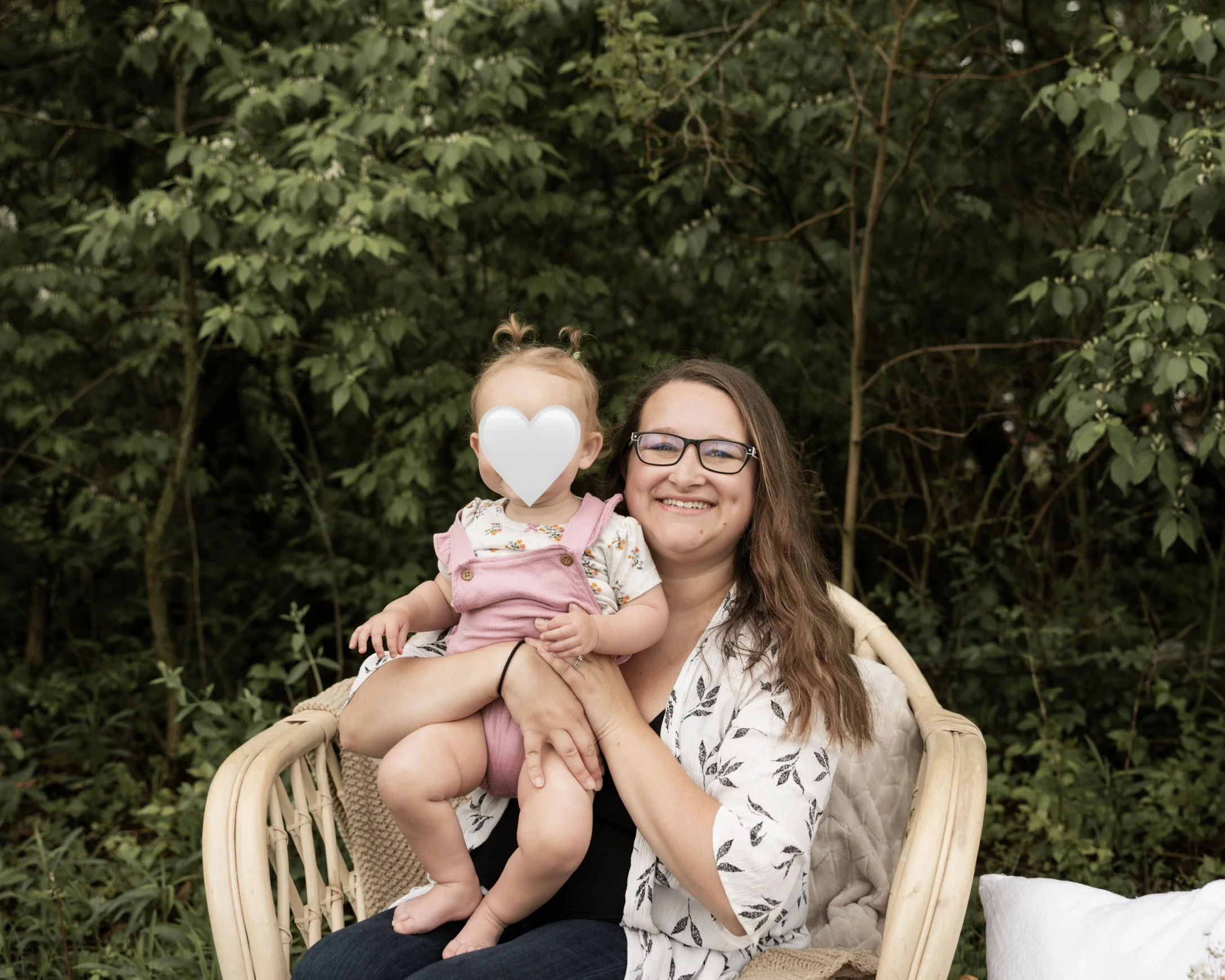 a mom sitting and smiling while holding her daughter