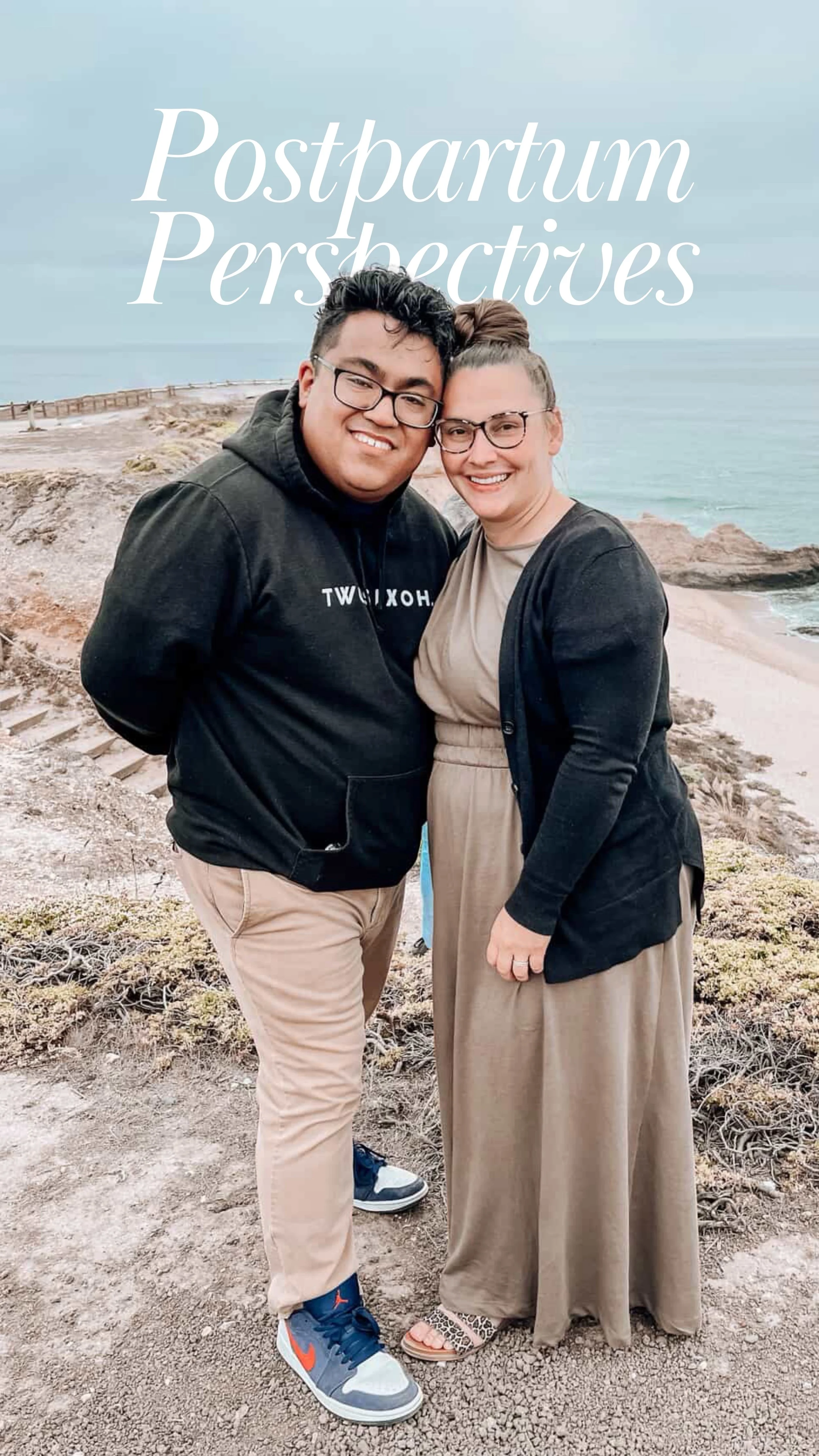 A man and a woman standing next to each other smiling while standing on a sandy cliff.