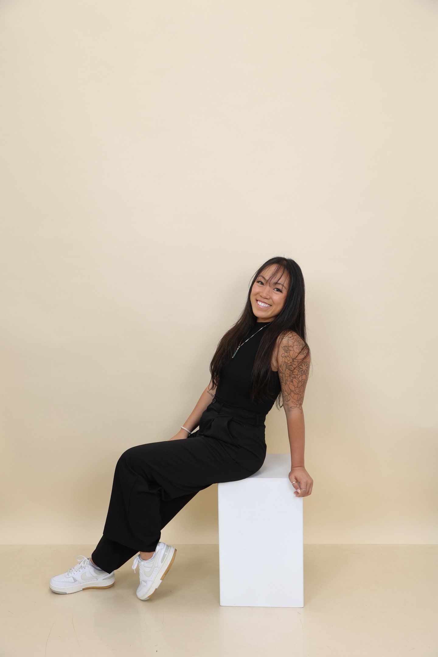 a woman sitting down and smiling into the camera