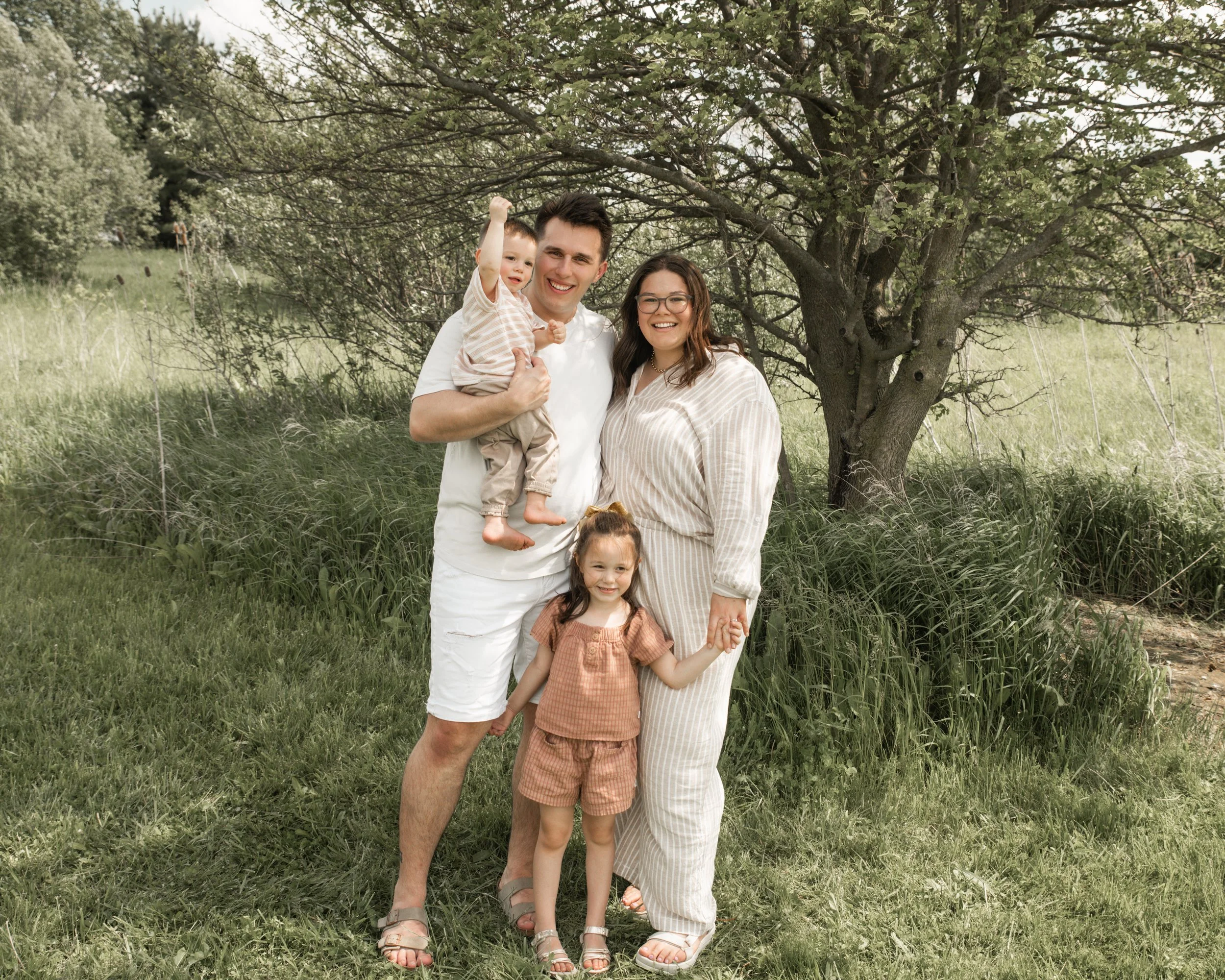 Annie our founder standing outside in a forrest with her husband, son and daughter