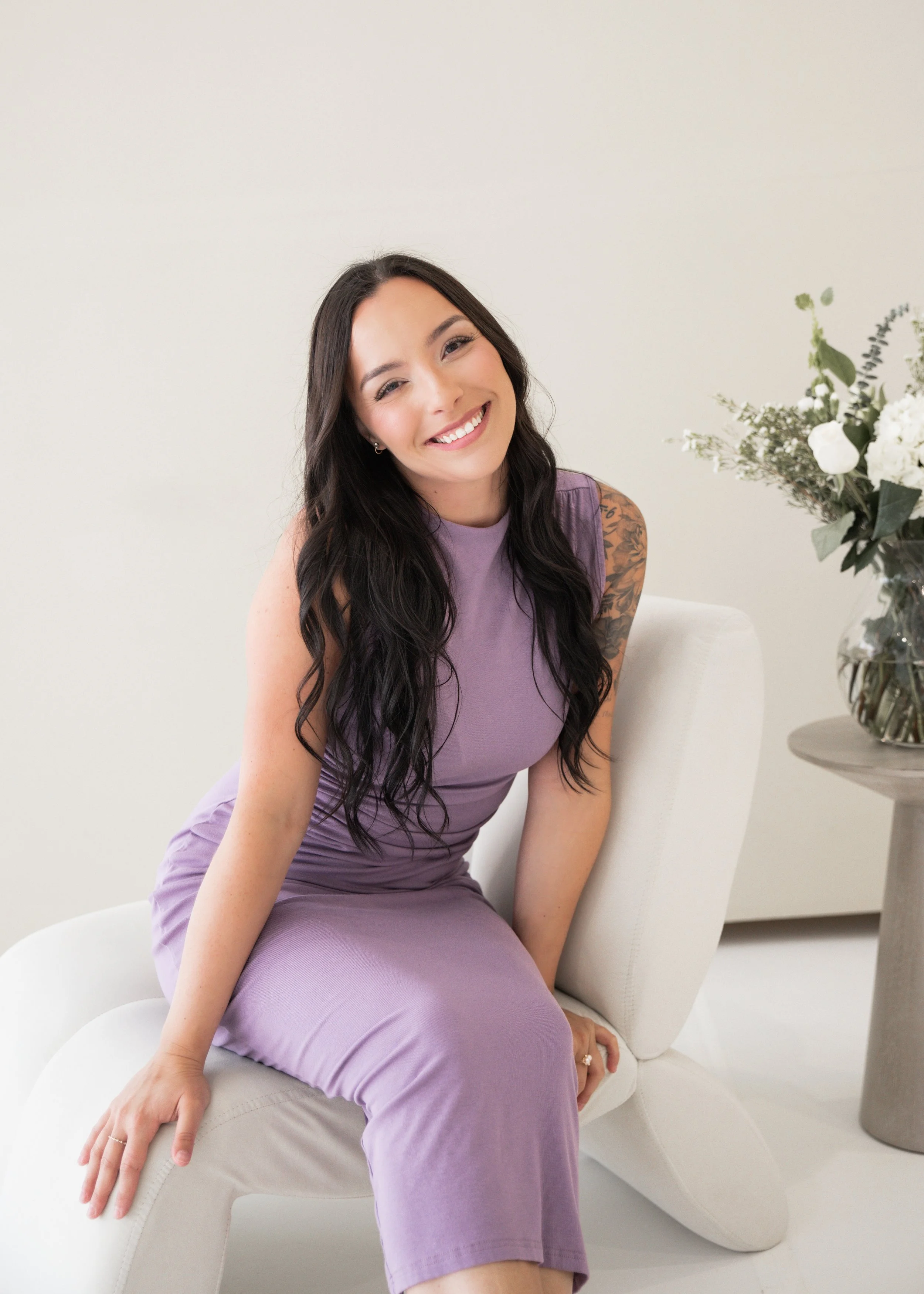 a woman sitting down and smiling into the camera
