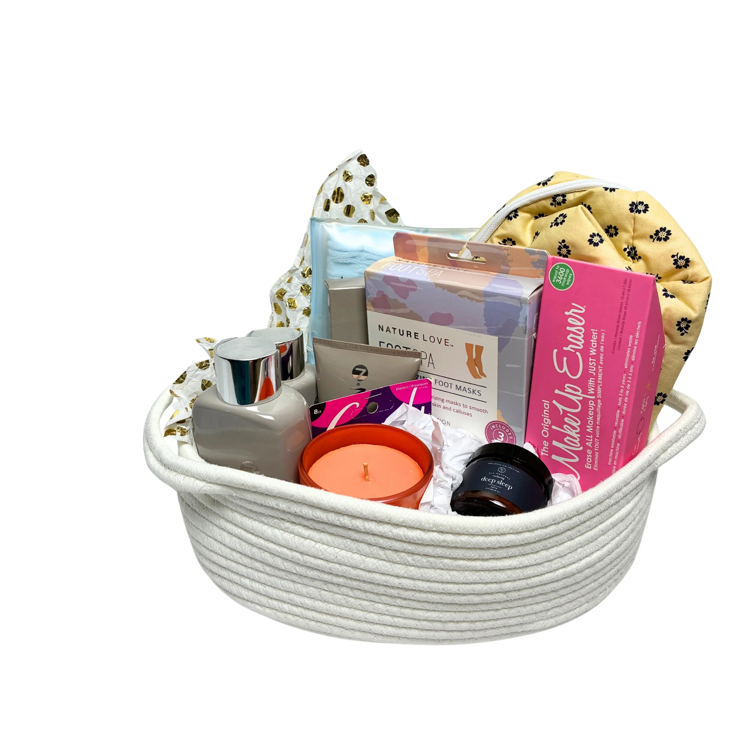 a silent auction basket filled with self care items such as candles, shampoo, makeup eraser, lotions, etc.