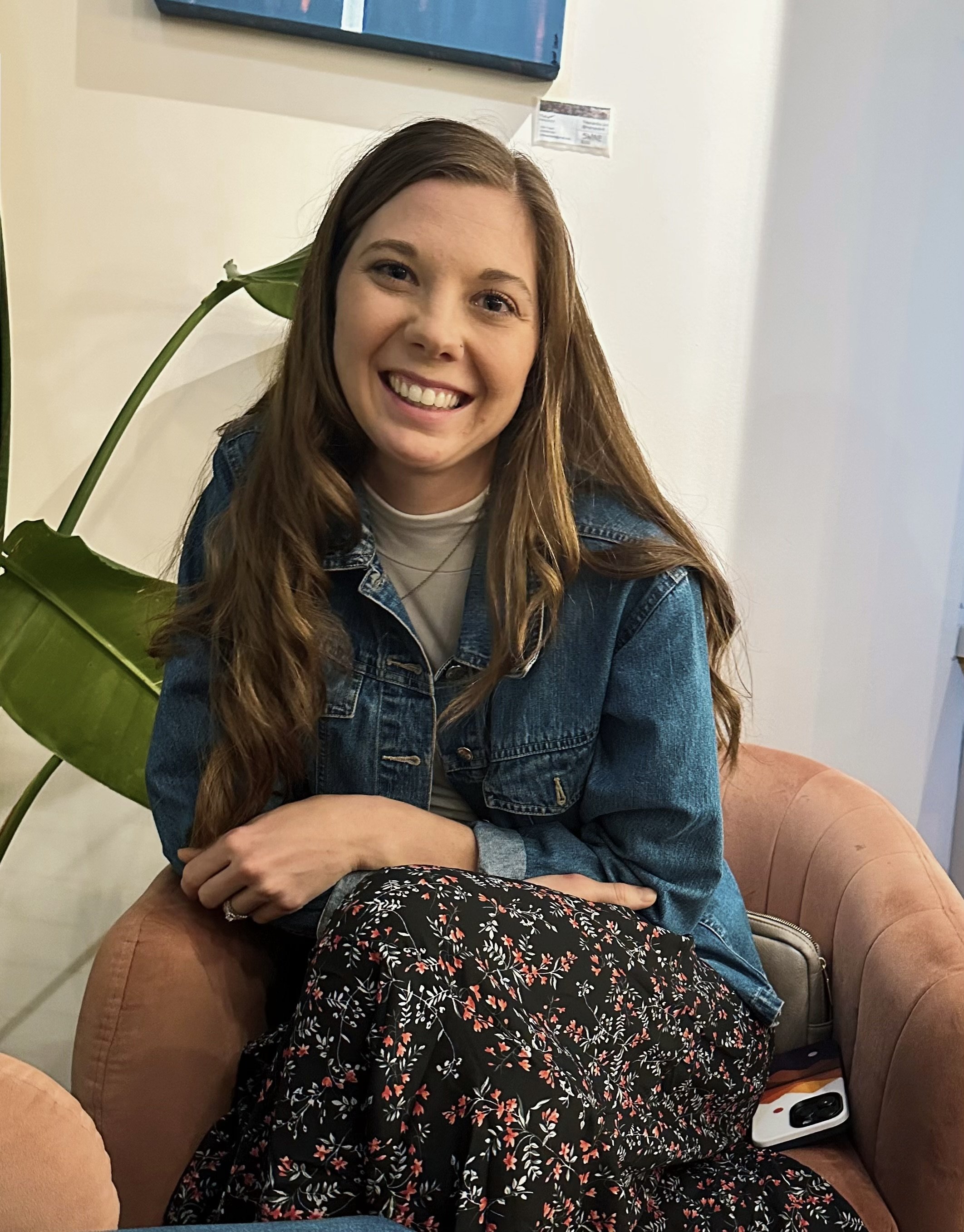 an image of a woman smiling into the camera while sitting down