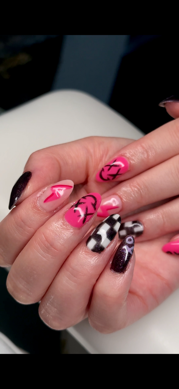 Nagellack med rosa, svart, och mönster på naglarna.