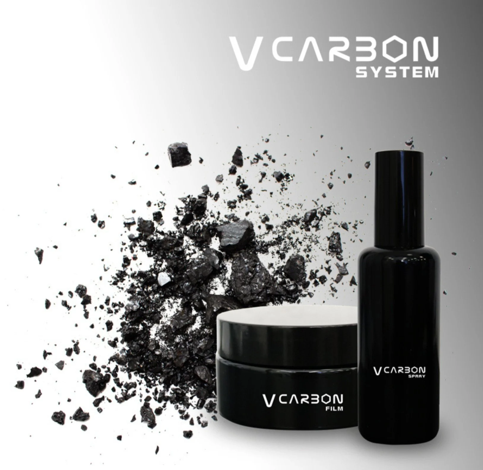 Svart sprayflaska och burk med texten ‘VCARBON FILM’ på, bredvid en kopp, mot en bakgrund med svart krossad sten och grå gradient.