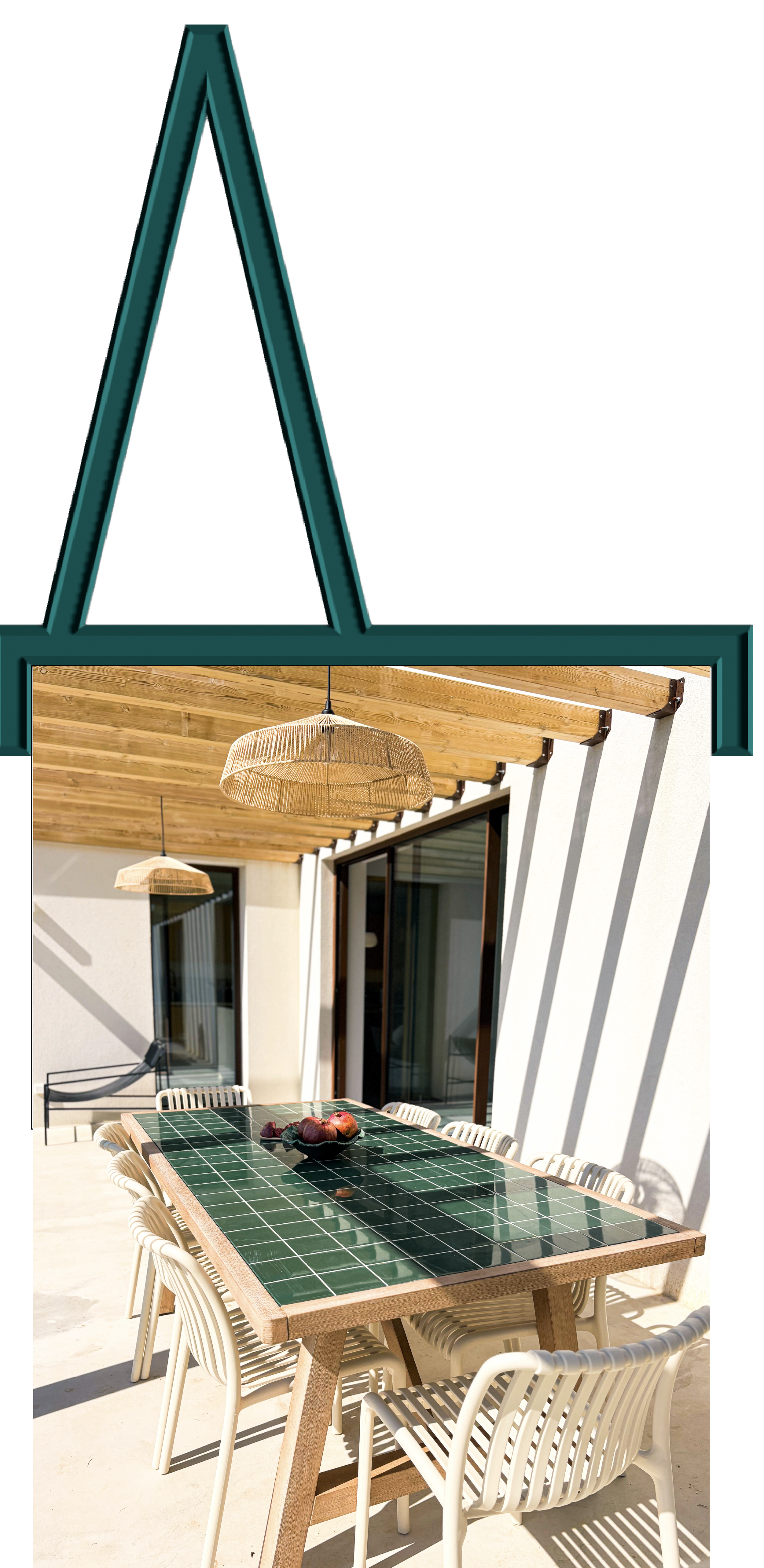 Área de varanda com mesa de madeira com tampo de azulejos verdes, cadeiras brancas ao redor, lâmpadas de suspensão de fibra natural, paredes brancas e teto de madeira, com sombra natural