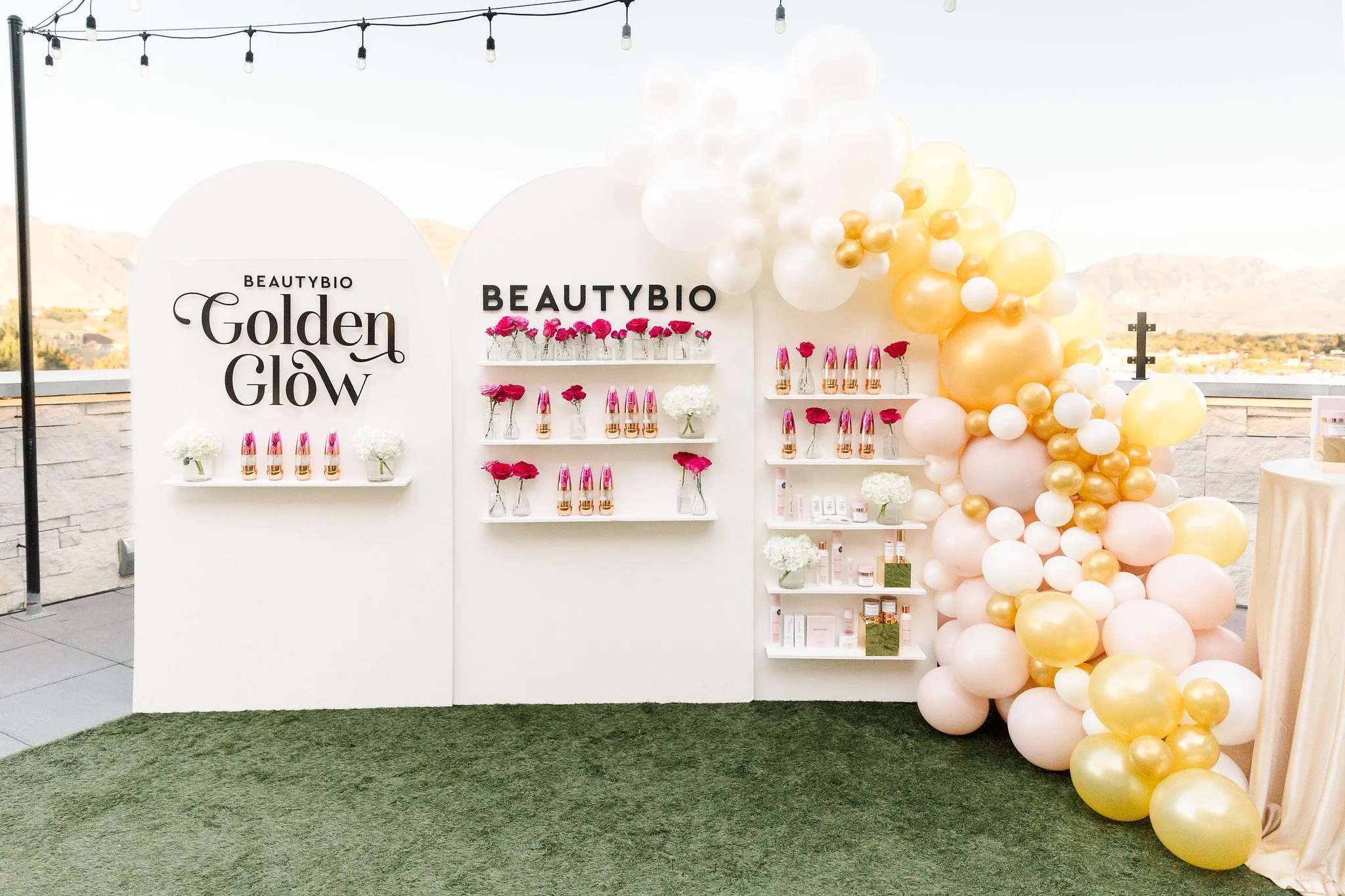 Decorative display with balloons, flowers, and skincare products for a beauty or skincare event outdoors.