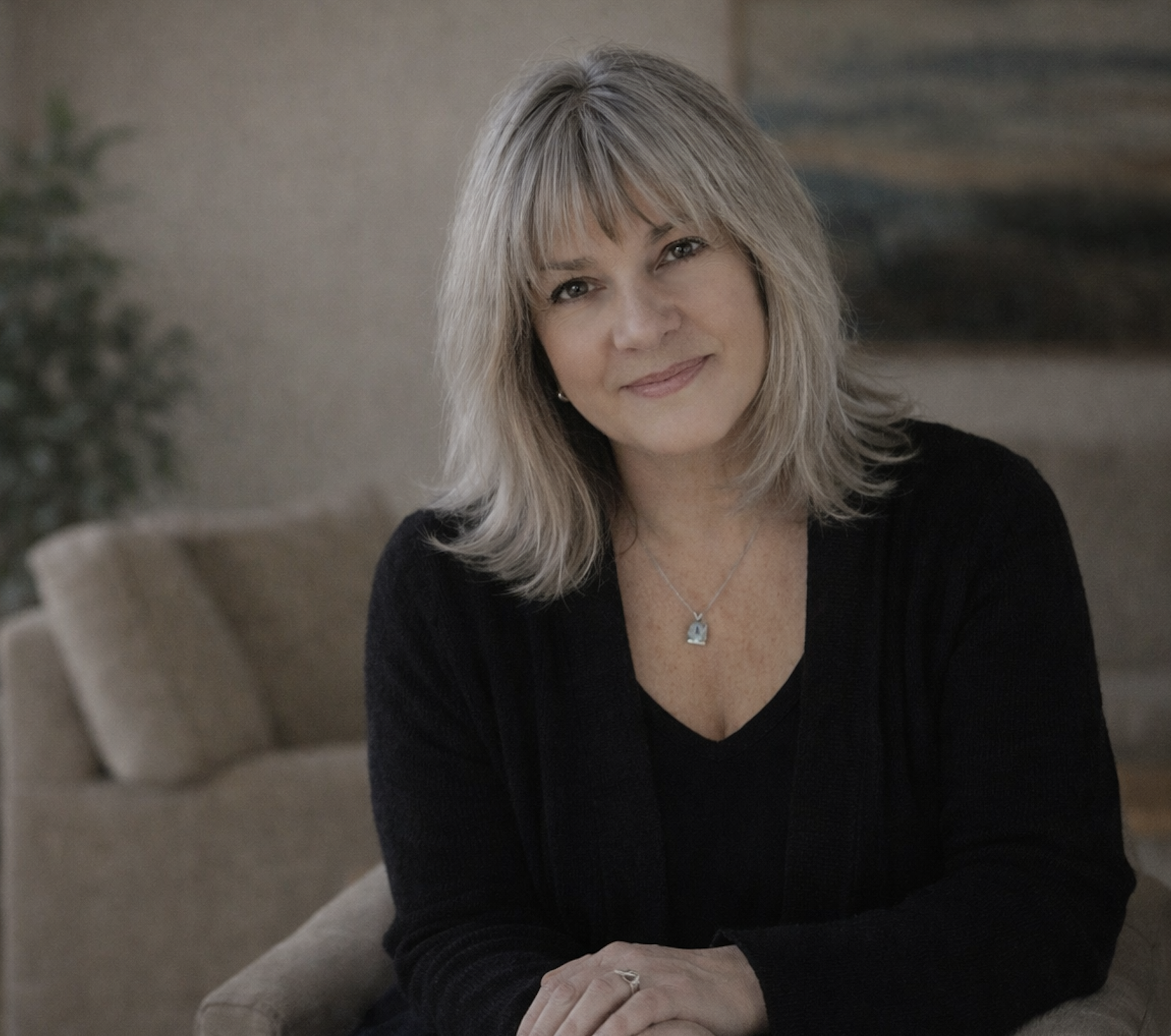 Pegge Suhm seated in a calm indoor portrait, reflecting her warm and supportive hypnotherapy approach.