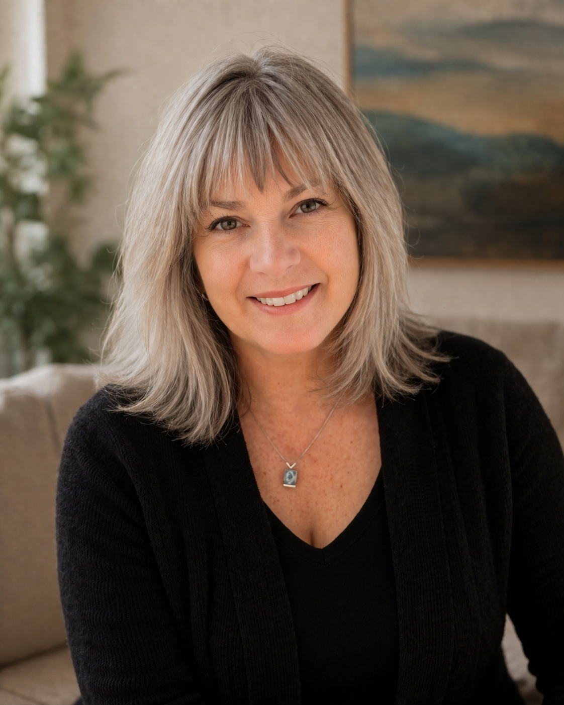 Pegge Suhm, professional hypnotherapist, smiling in a warm indoor portrait.