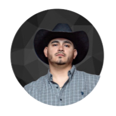 A man wearing a black cowboy hat and a blue checkered shirt, looking at the camera.