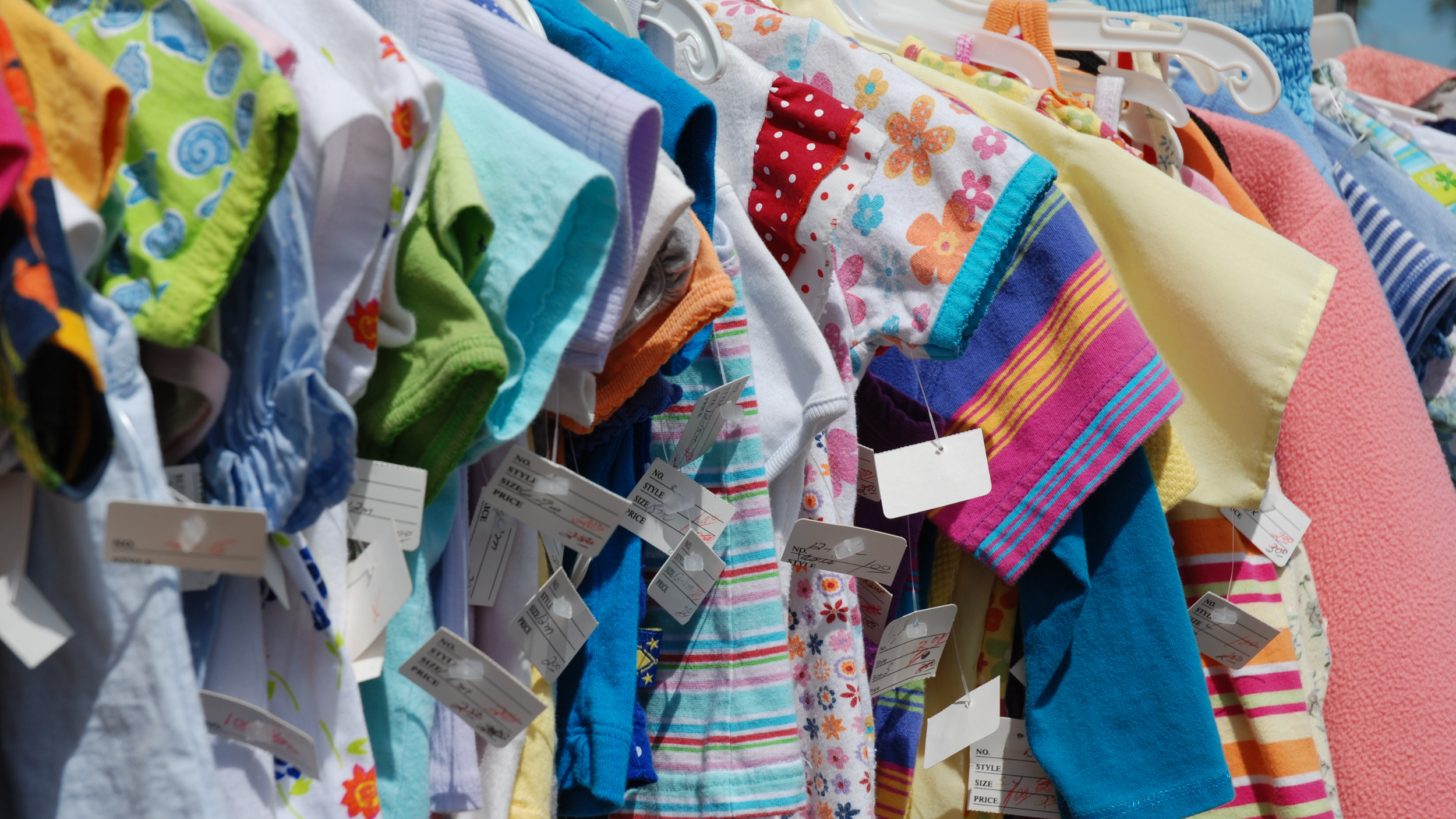 a bunch of children's resale clothes on a rack in Chic Kids.