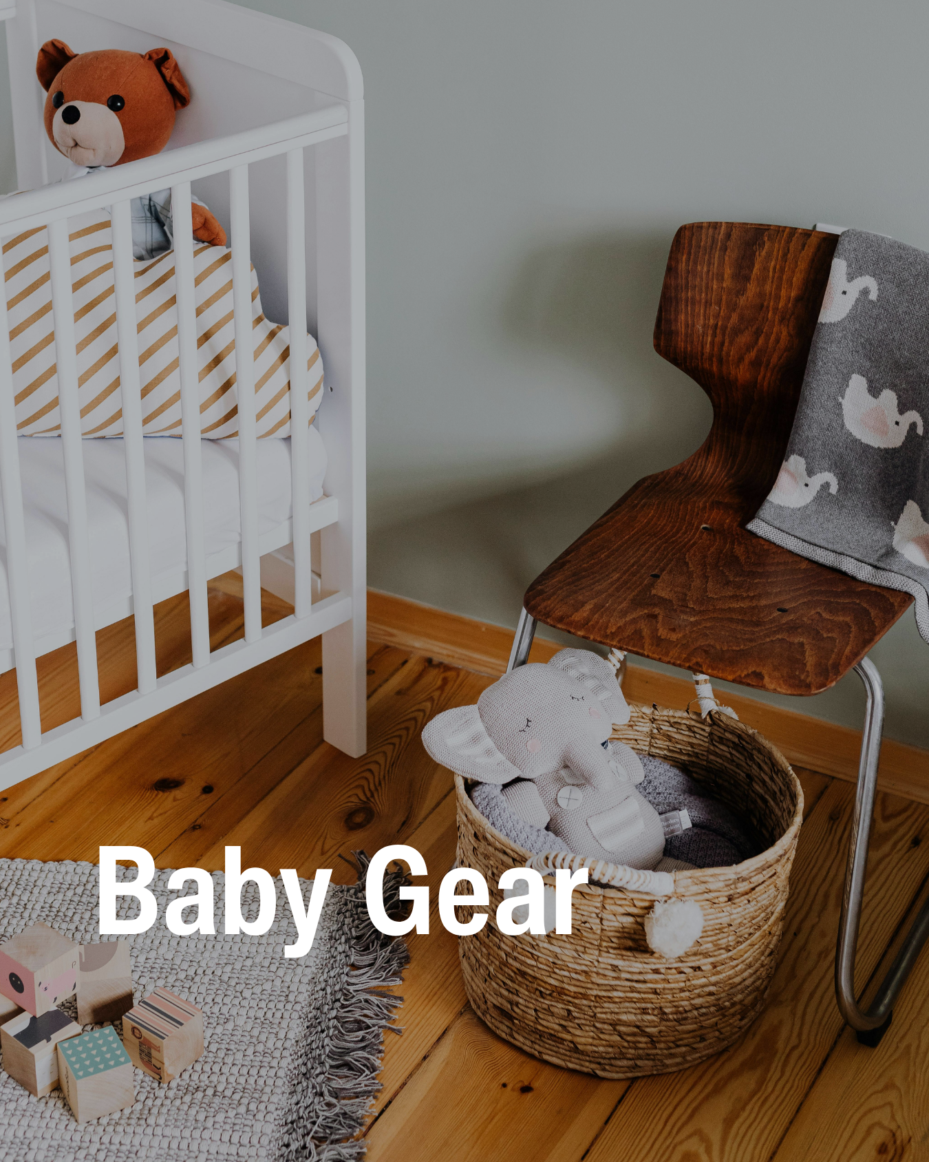 Neutral nursery scene with crib, chair, basket of toys showing the resale baby gear Chic Kids sells.