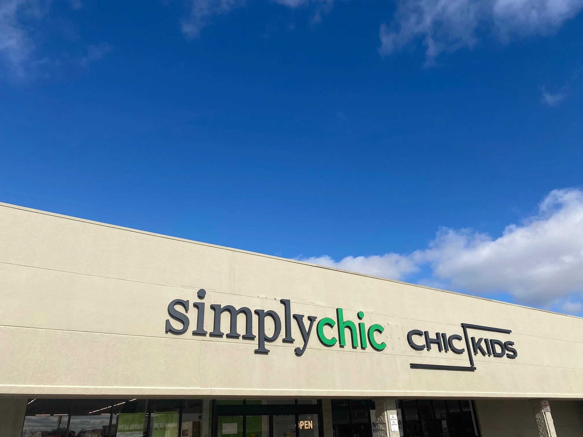 The storefront for simply chic and CHIC KIDS under a blue sky with a few clouds.