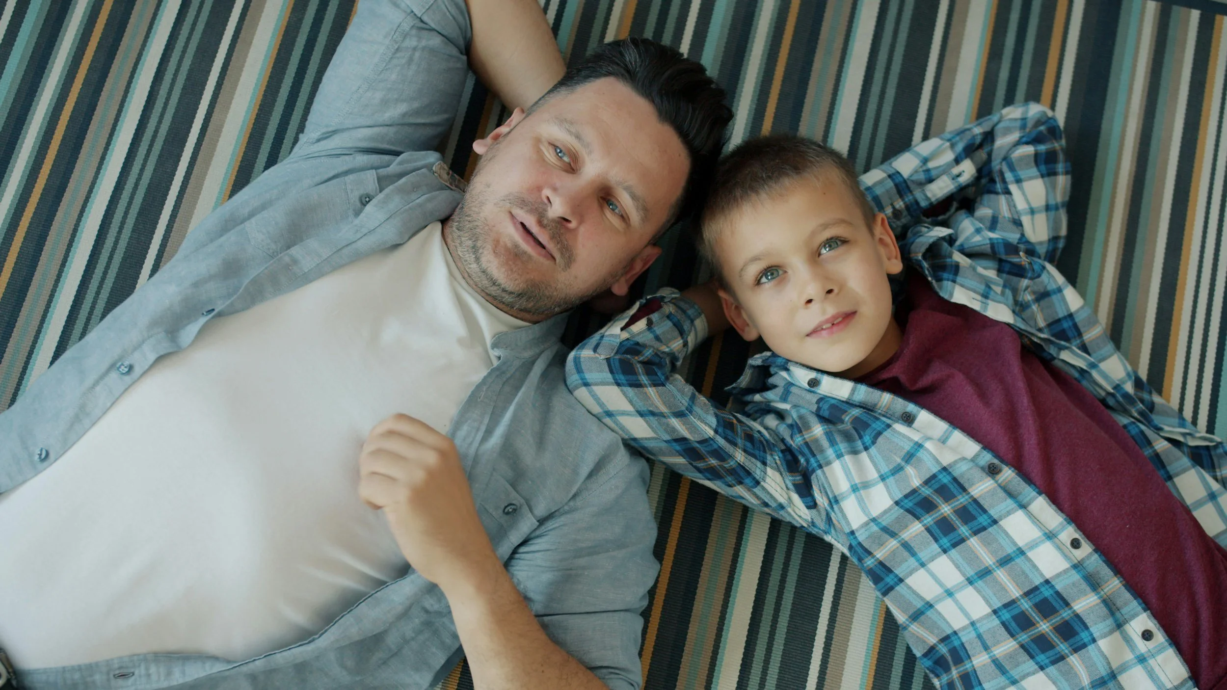 A father and son lying on the floor