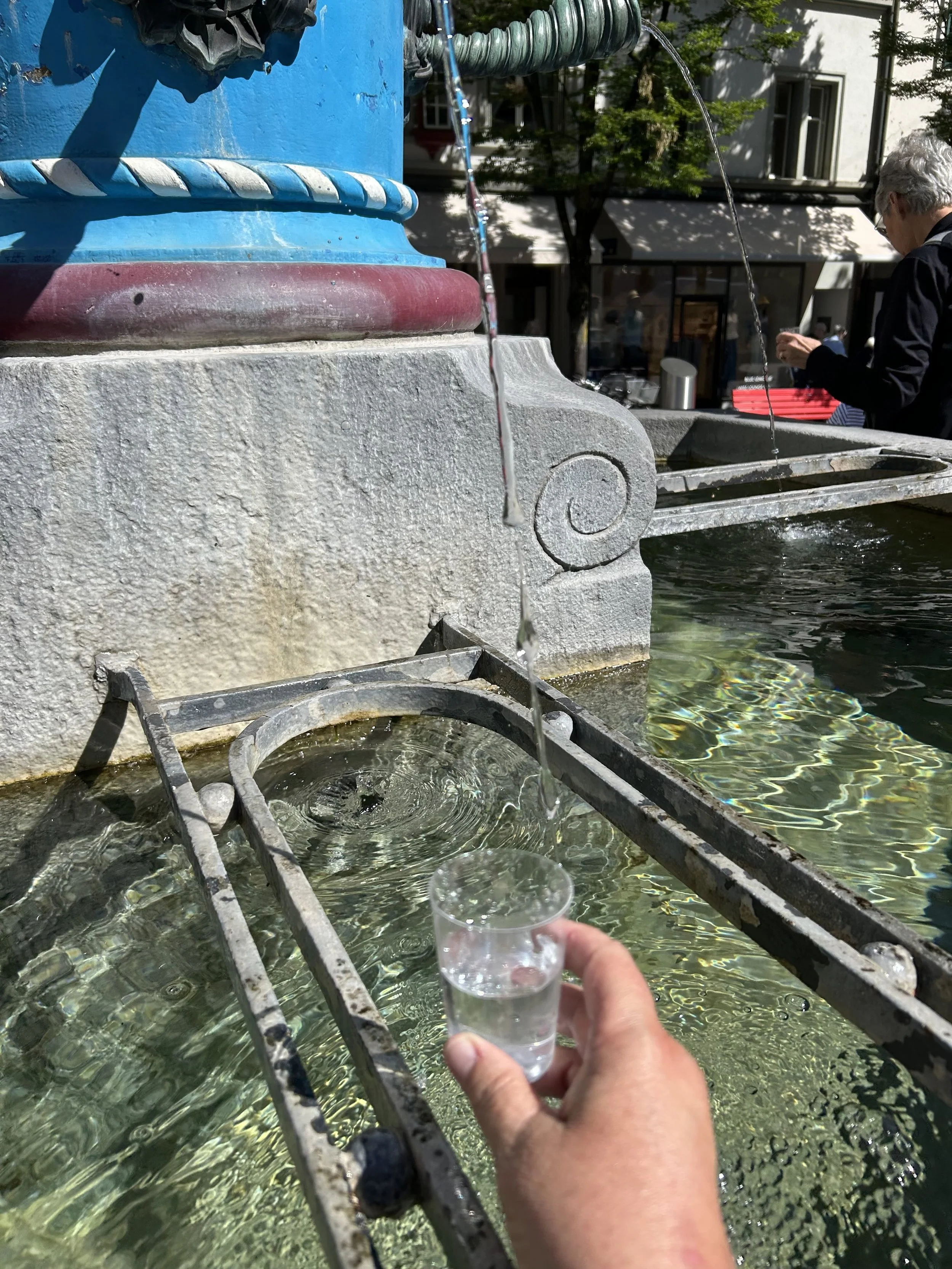 Filling a glass with water from a fountain in Weggis, Switzerland