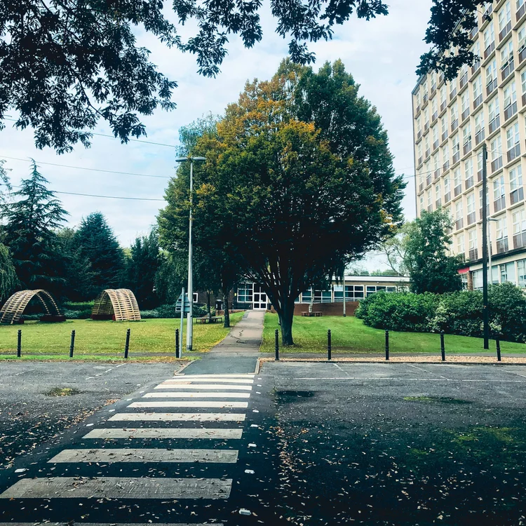 A crosswalk leading toward a green community park