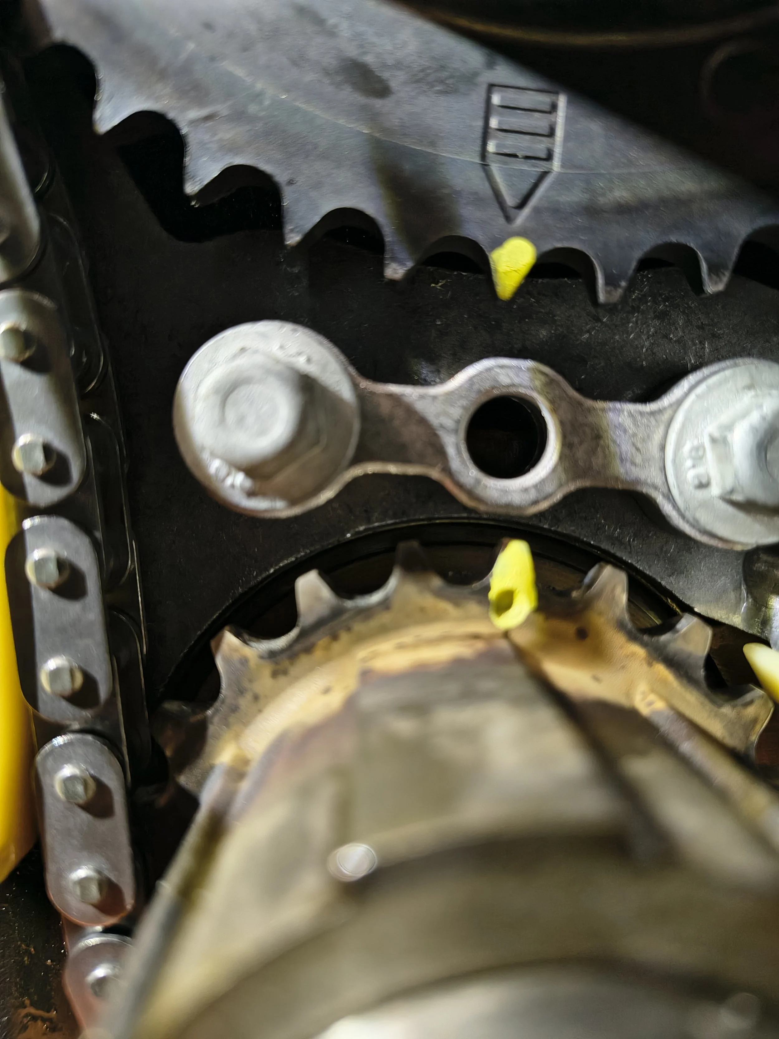 Close-up view of metallic gears and chains inside a mechanical device, likely part of a bicycle or machinery.