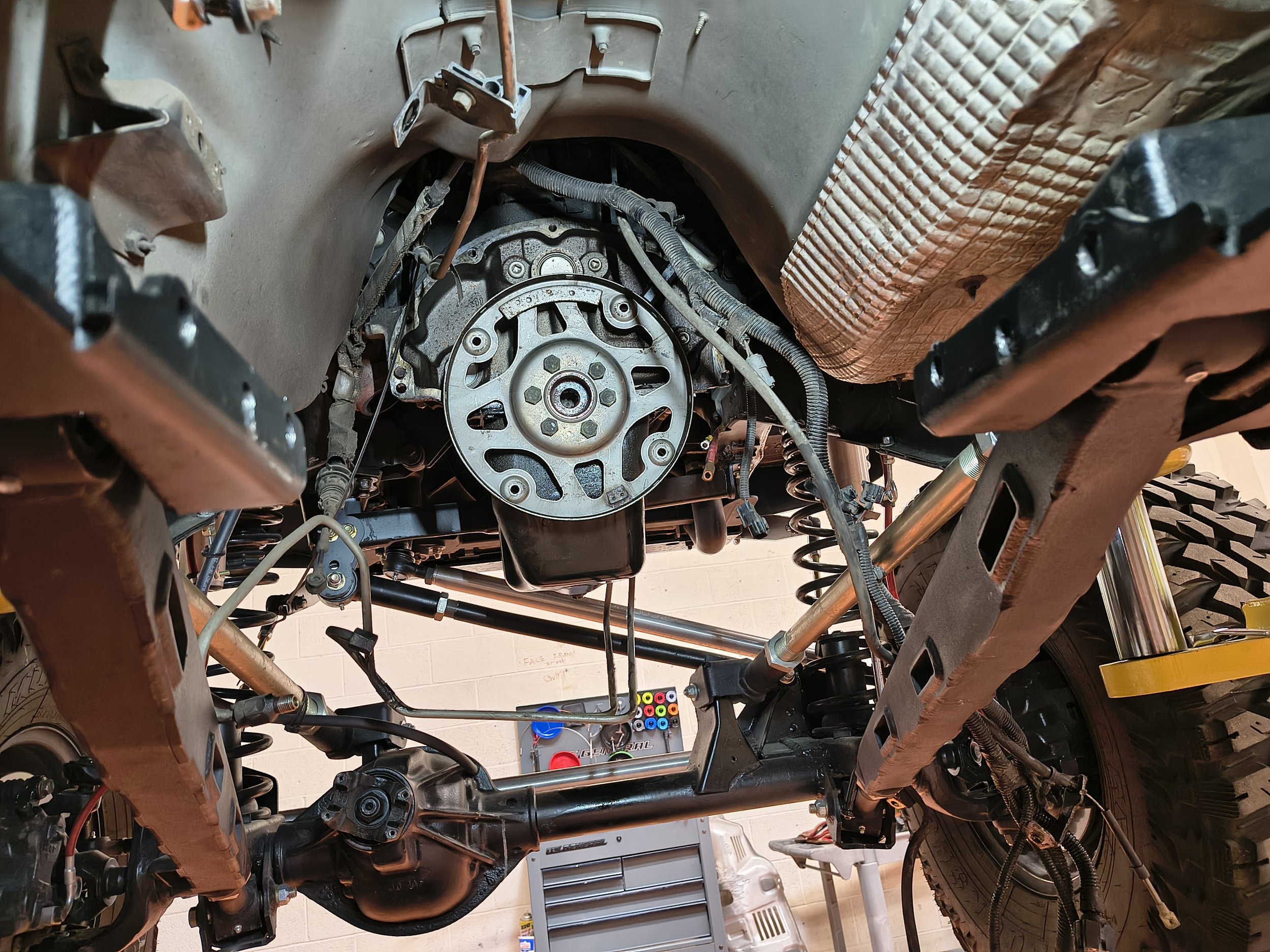 The image shows the interior of a vehicle with the dashboard and engine components exposed, indicating ongoing repairs or modifications.