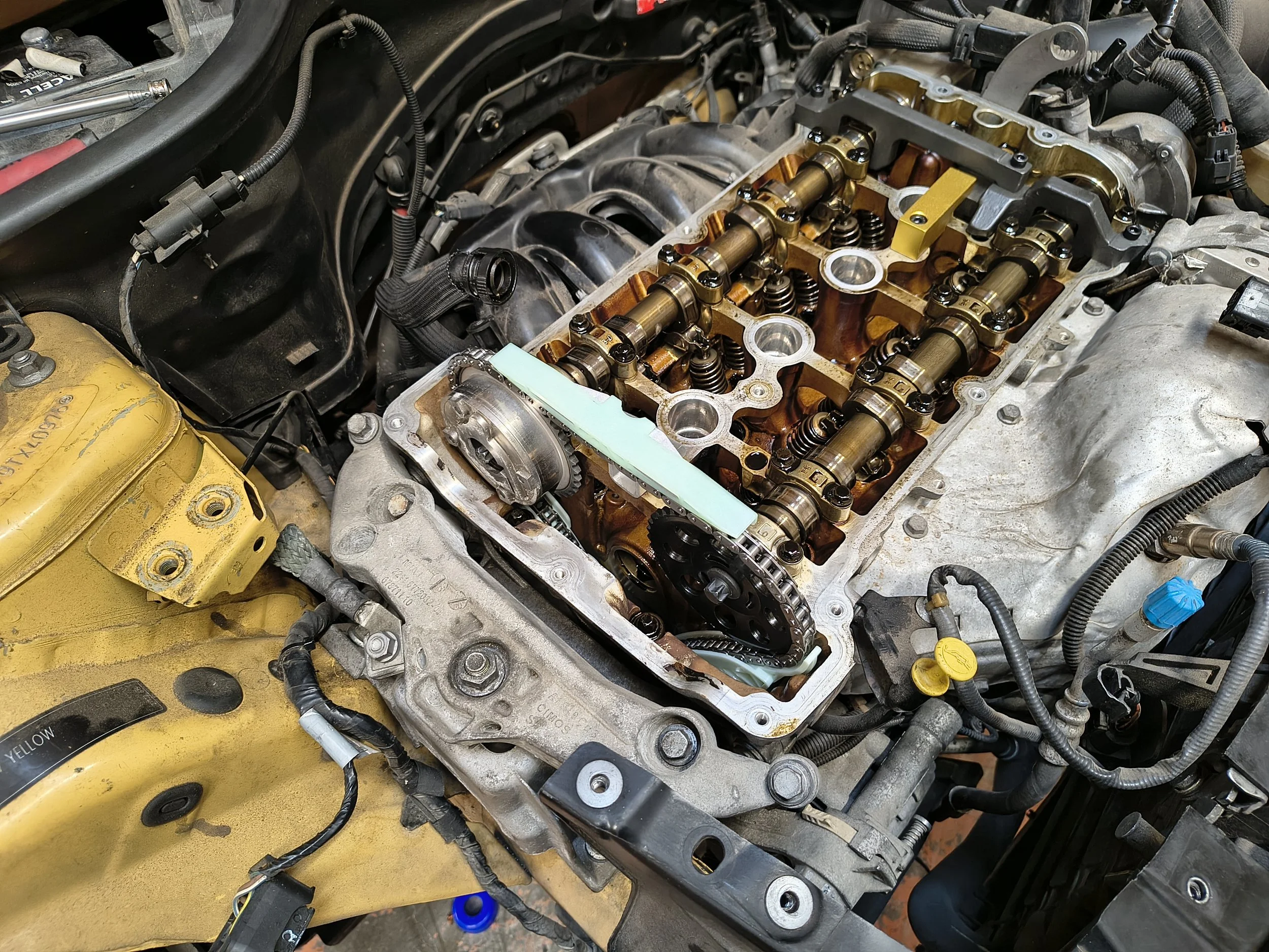 Close-up of an internal car engine showing the camshaft and valve springs with the valve cover removed.