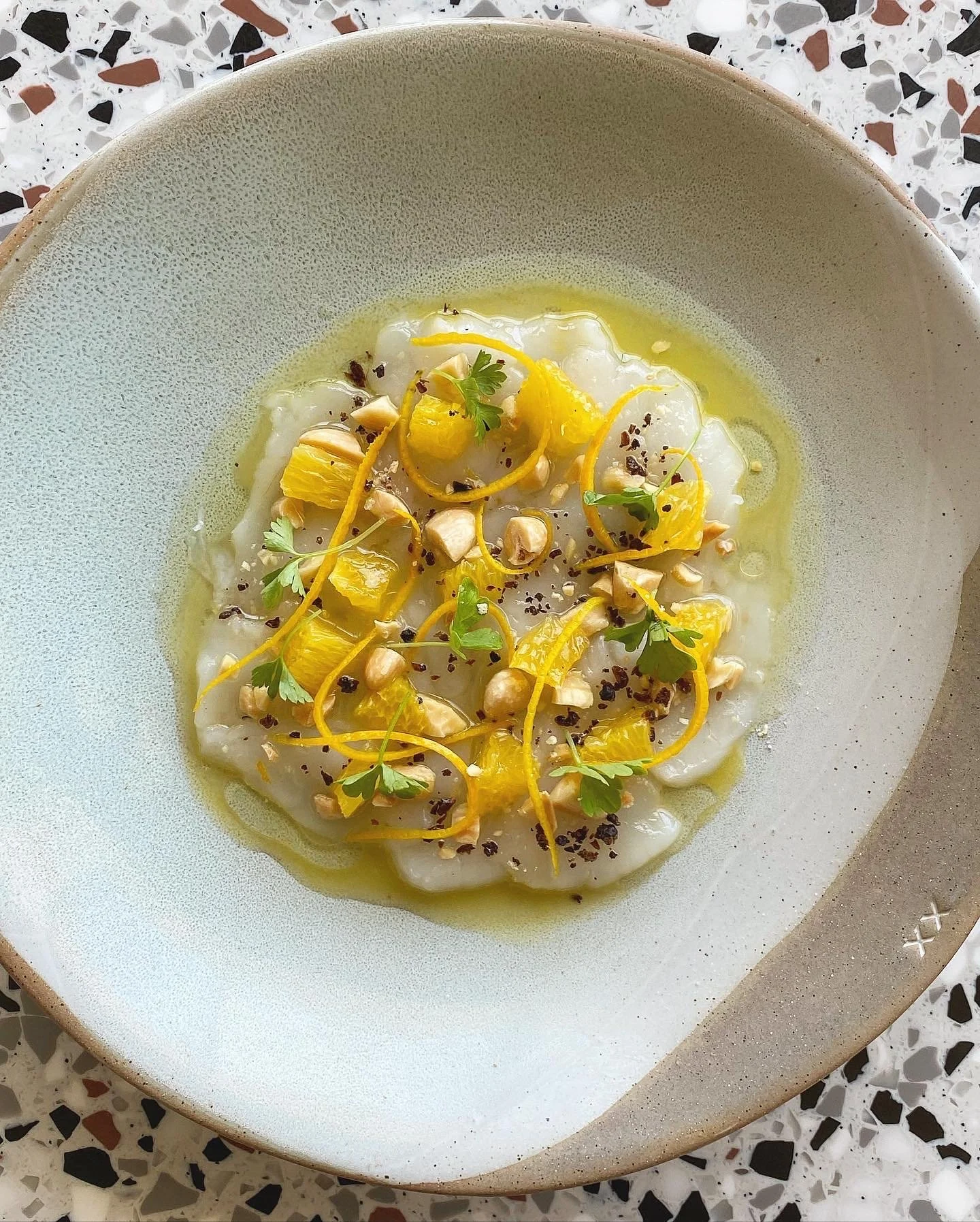 Hand-crafted dish of Shark Bay scallop crudo with juniper, orange, almonds and citrus dressing at a Studio Cibo's private chef in Perth