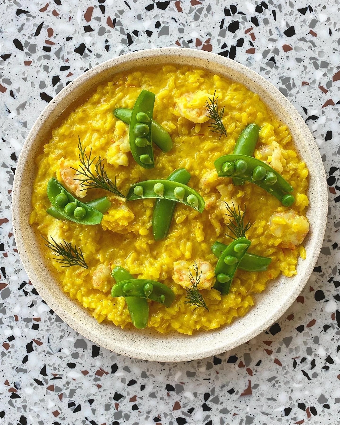 Saffron prawn risotto with dill, prawn's head chilli oil and peas, plated by Studio Cibo private chef