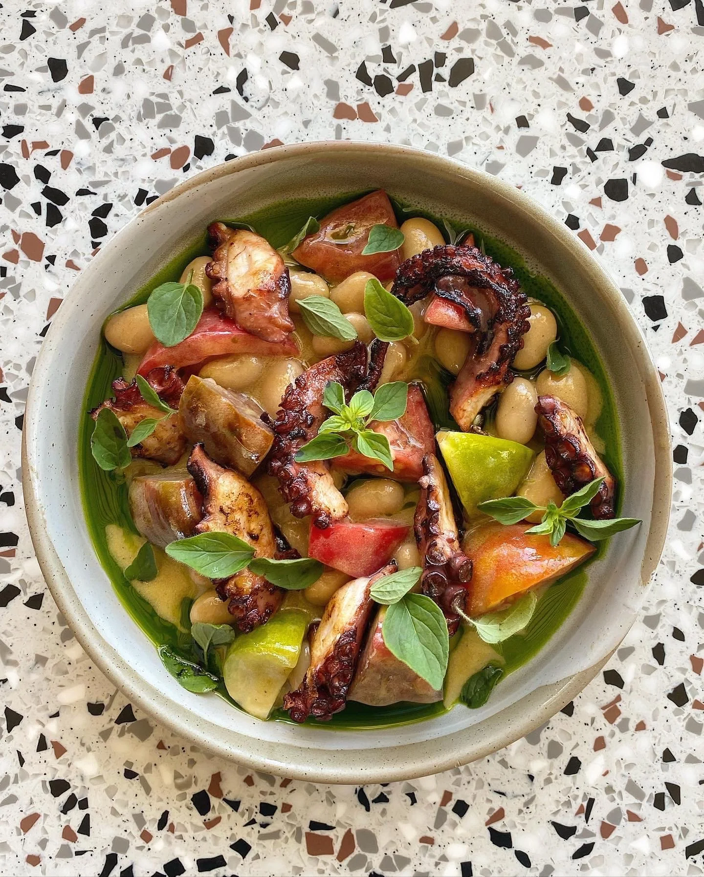 Studio Cibo private chef preparing seasonal Italian dishes, grilled octopus with heirloom tomatoes, butter beans and basil oil