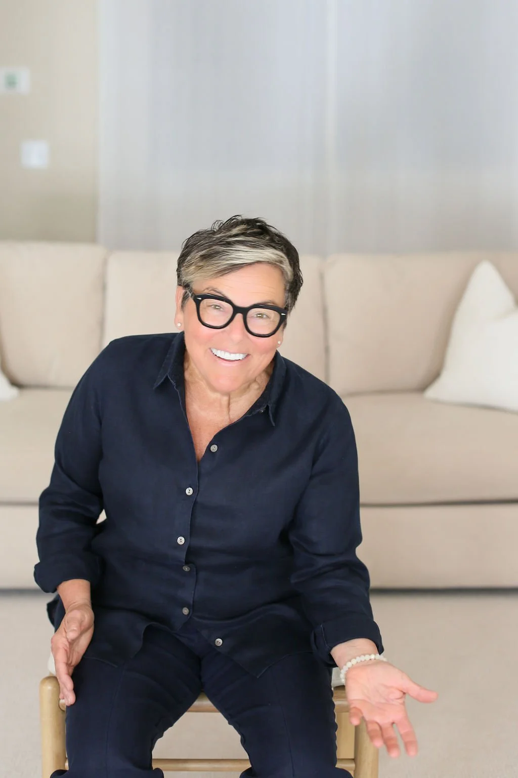 Home coach sitting in a calm living room, representing a supportive and mindset-based approach to decluttering.