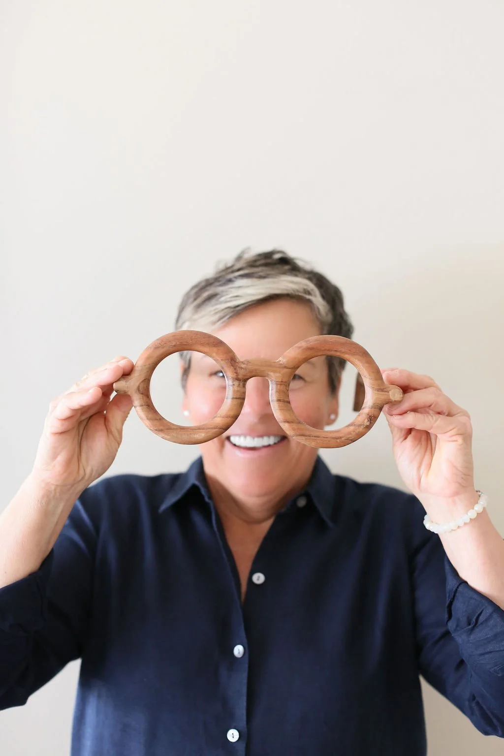Home coach holding oversized glasses, representing a new perspective on why decluttering feels so hard.