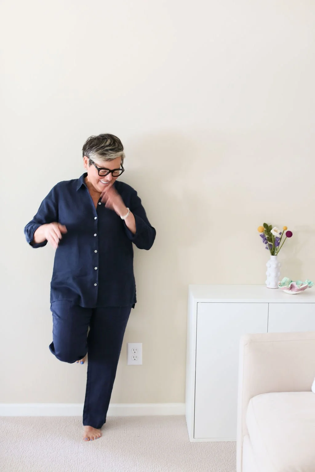 Home coach smiling in a calm home setting, reflecting the inside-out approach to decluttering and organizing.