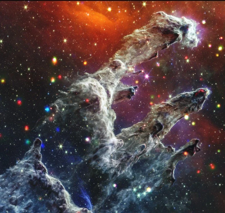 An image of a nebula in space with colorful stars and cosmic clouds.