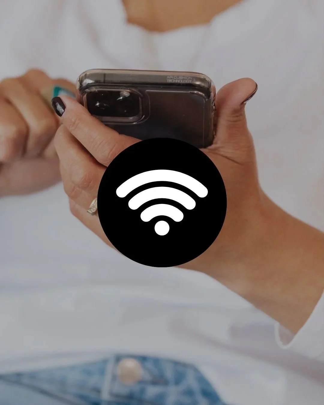 Close-up of a person holding a smartphone with a large Wi-Fi symbol overlay.
