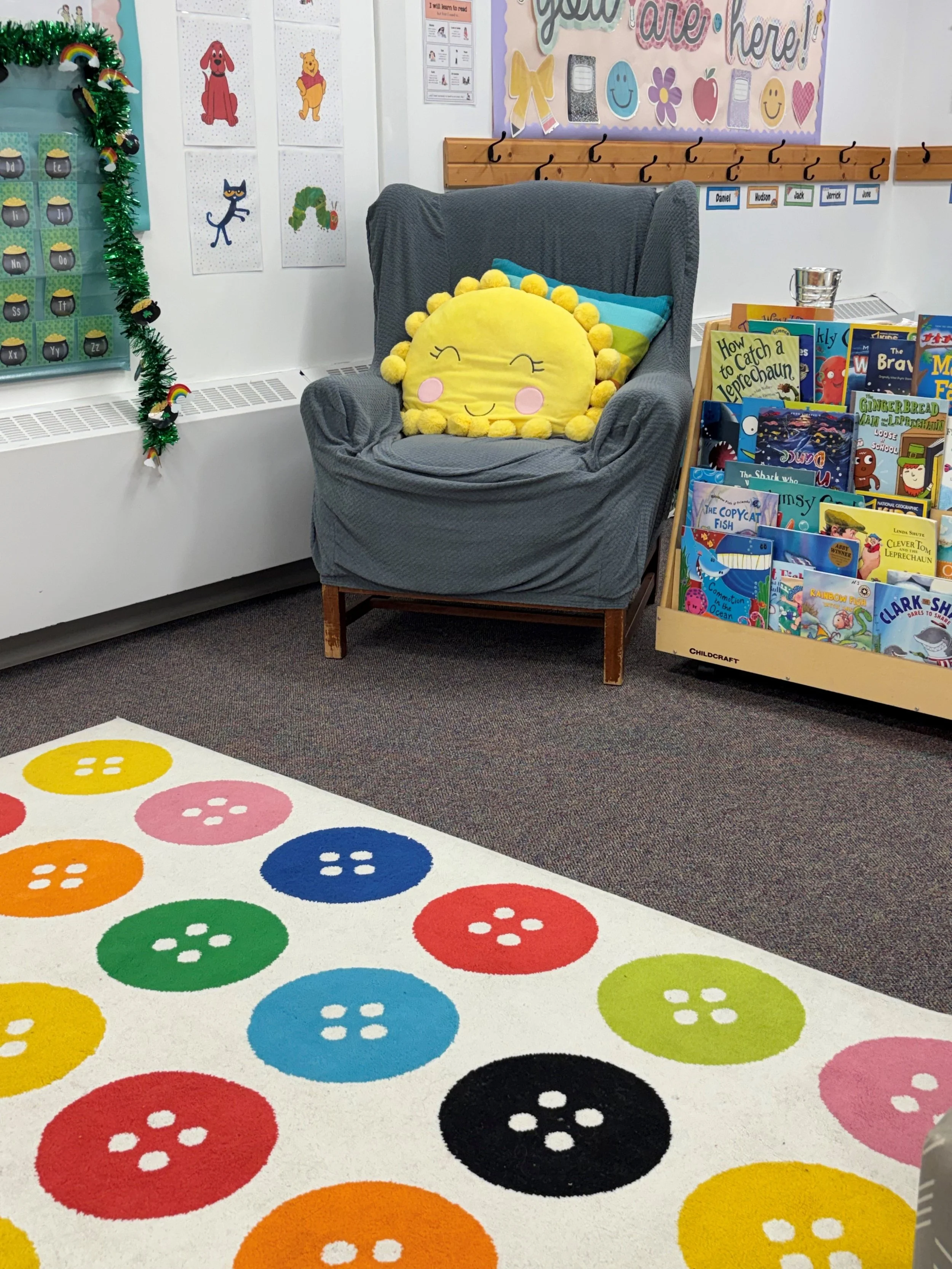 Colorful rainbow-themed rug with large button designs scattered across it.