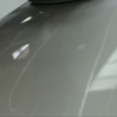 Close-up of a shiny, reflective surface, possibly a gray or metallic floor or countertop.