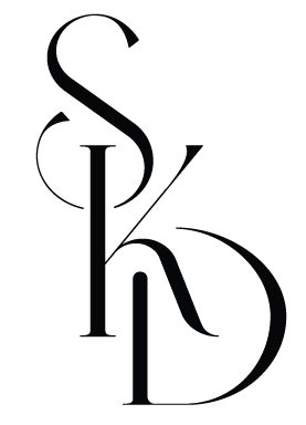 A stylized black and white logo with the letters S, K, and D arranged vertically.