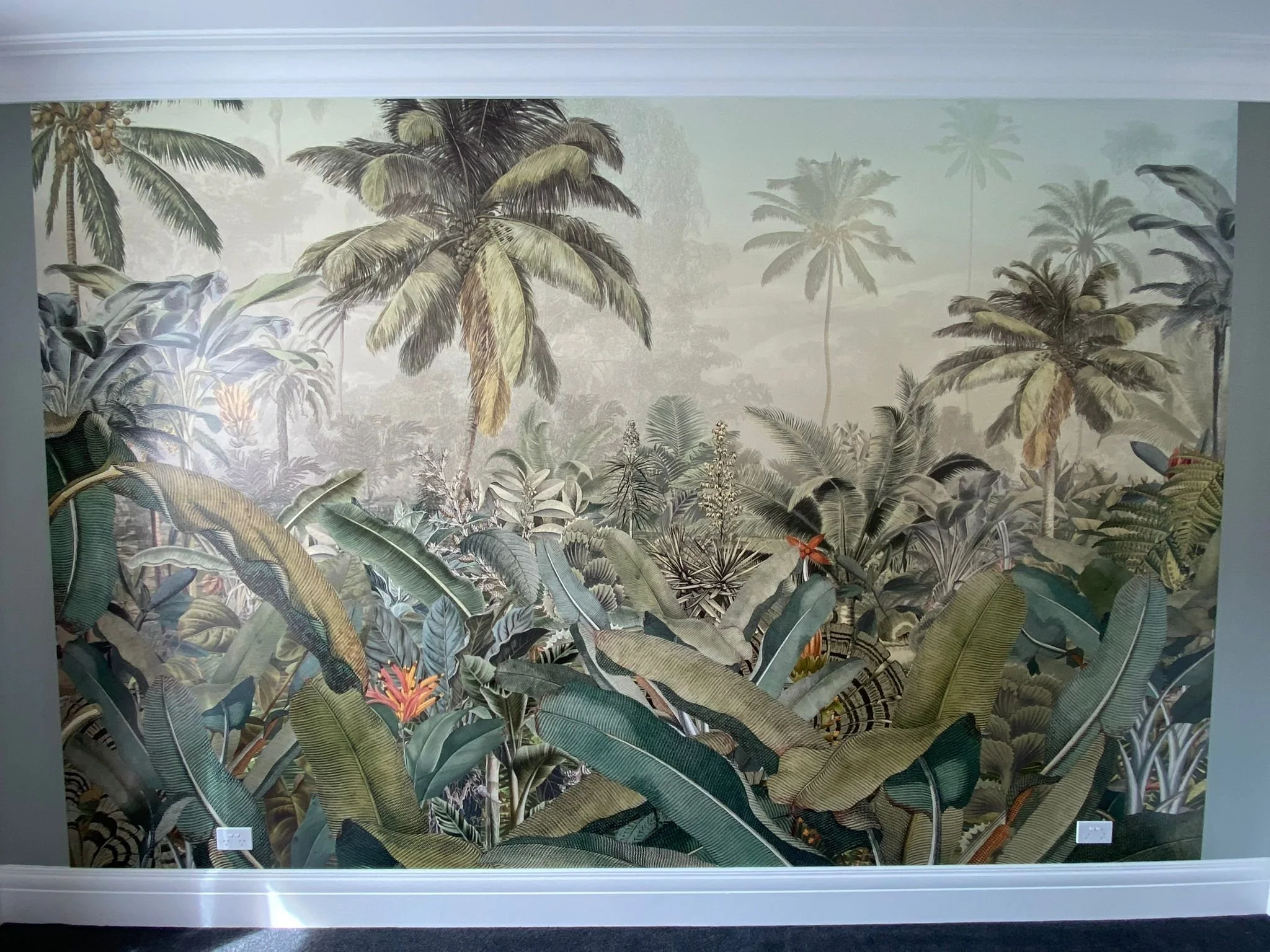 Tropical jungle mural with lush green foliage, banana and palm trees, and vibrant flowers.