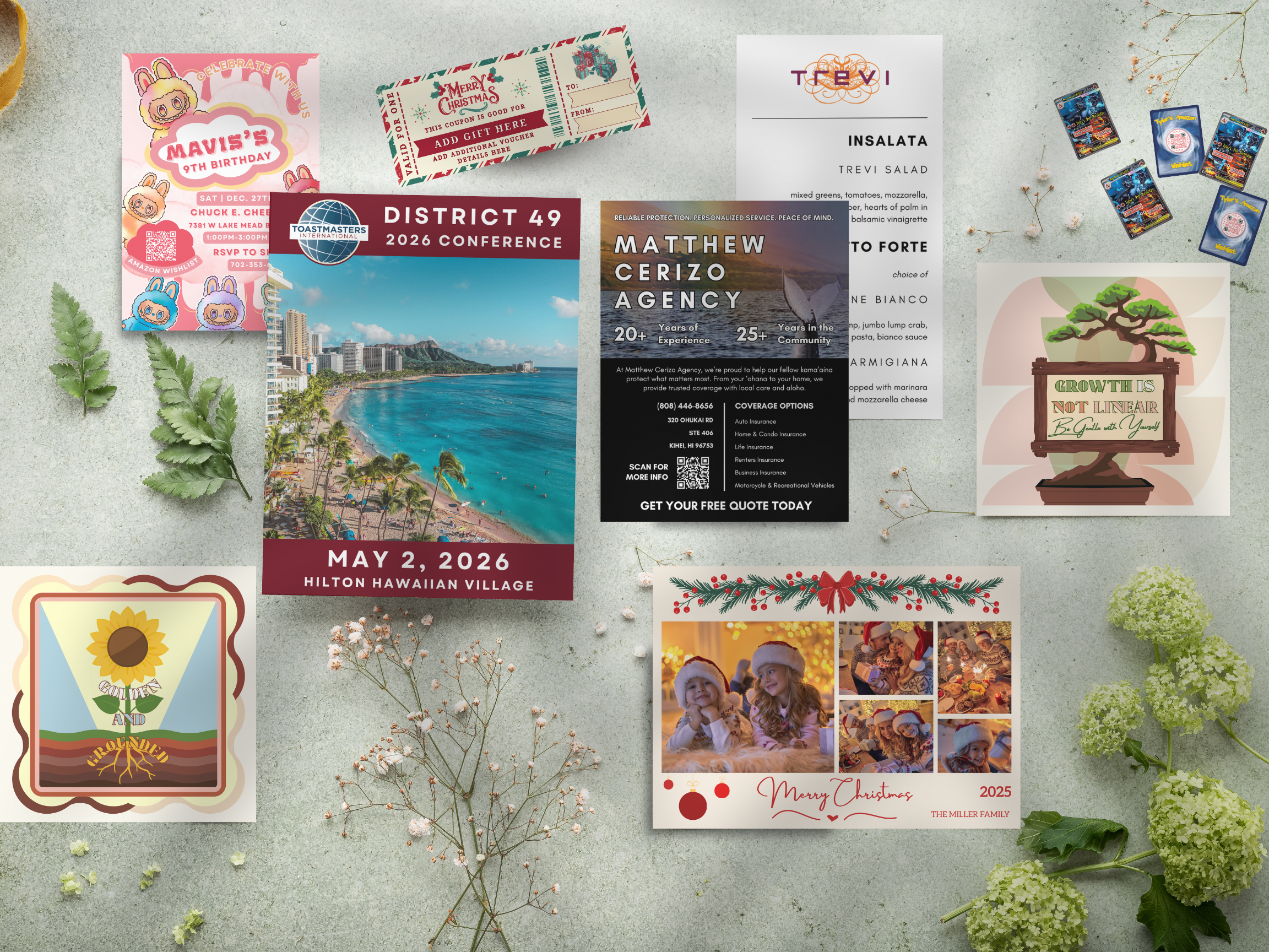 A flat lay of various holiday and event-themed cards and snapshots, surrounded by green leaves, small white flowers, and hydrangea flowers, on a light textured surface.