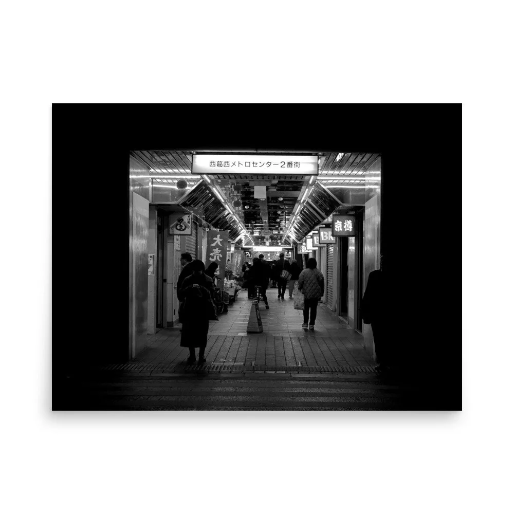 Black and white street photo of shoppers waiting at the dark end of a shopping strip in Nishikasai in Tokyo