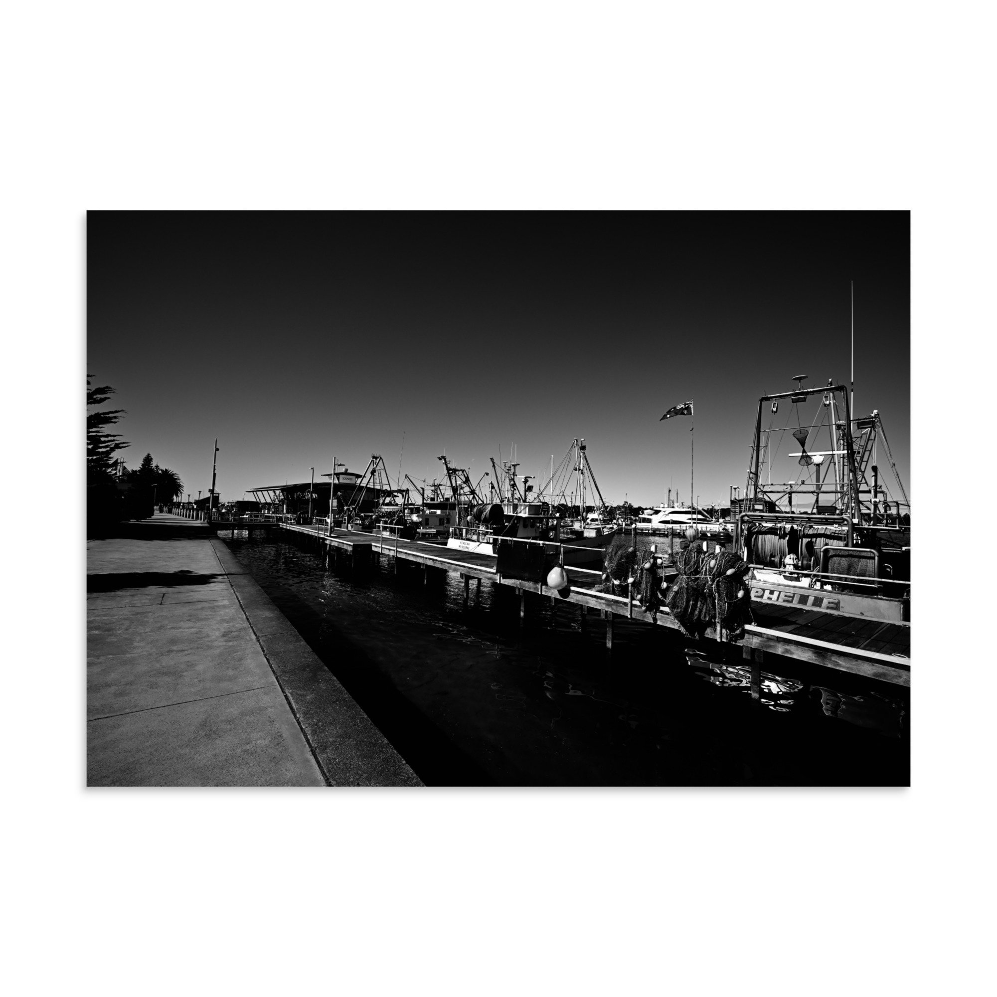 A high resolution black and white print of fishing boats lined up at the docks at Lakes Entrance, Victoria.