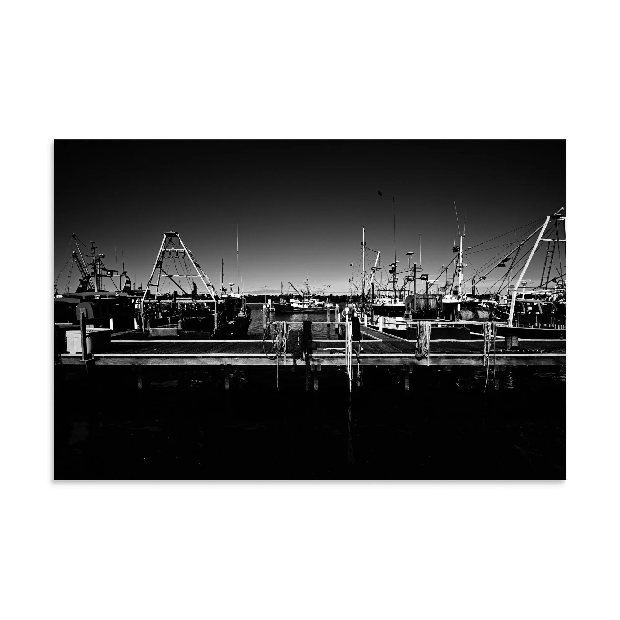 A high resolution black and white print of fishing boats lined up at the docks at Lakes Entrance, Victoria.