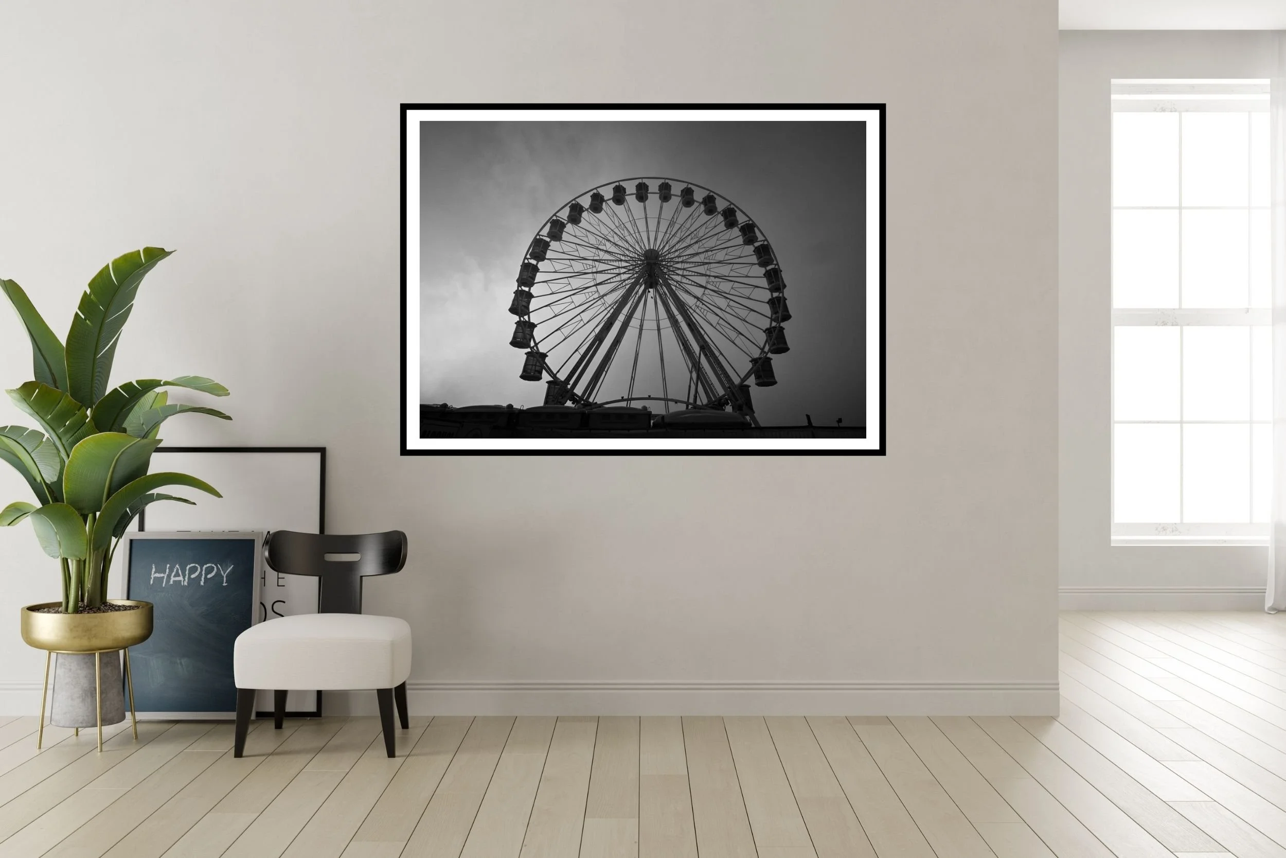 A striking black and white photograph of a carnival ferris wheel set against a foggy and cloudy background