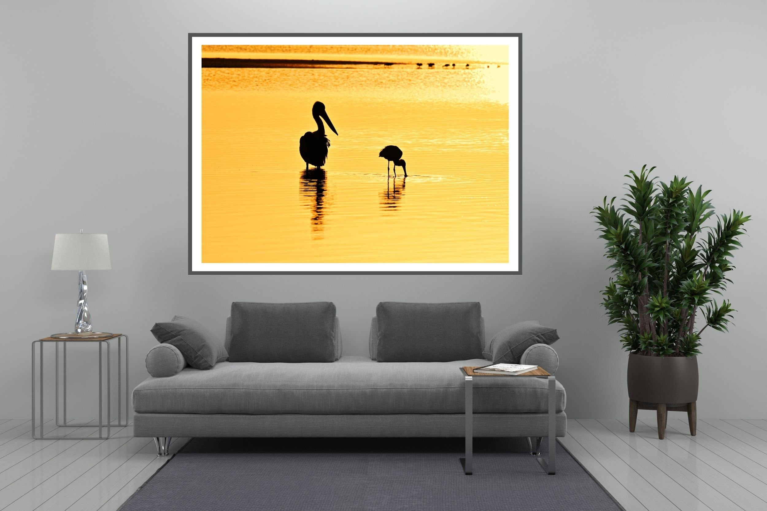Two Australian native birds (pelican & spoonbill) silhouetted against the lake waters in the morning golden-hour at Lake Tyers, Victoria Australia.