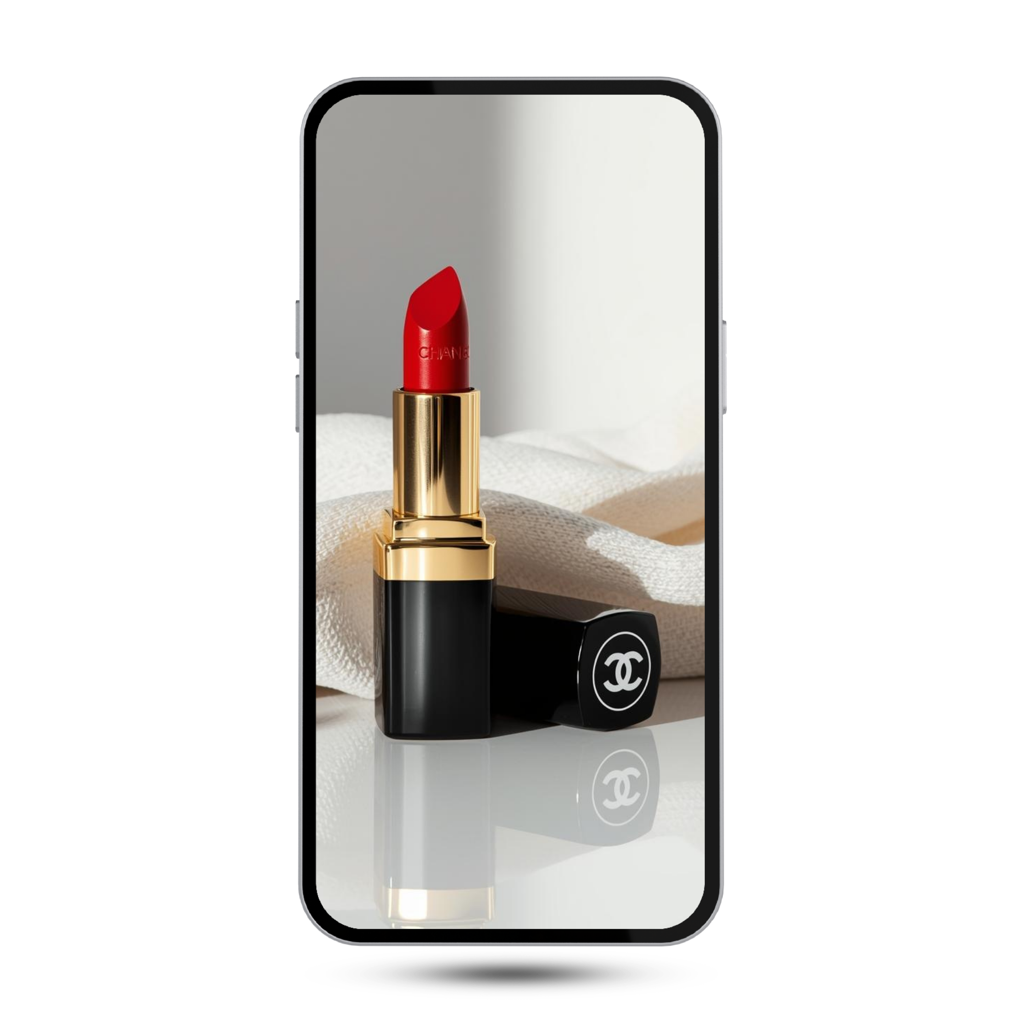 Close-up of a smartphone displaying a lipstick product with a black and gold case, with a Chanel logo, resting on a white textured surface with a beige cloth underneath.