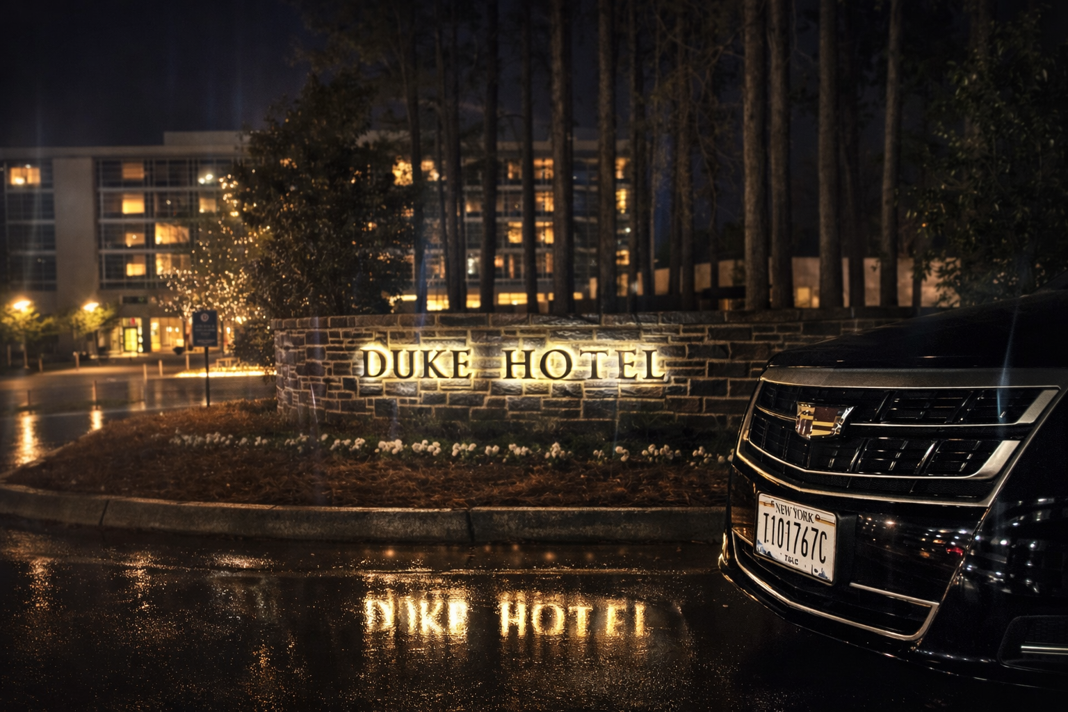 Nighttime view of the Duke Hotel with illuminated sign and a black car with Connecticut license plate in the foreground.