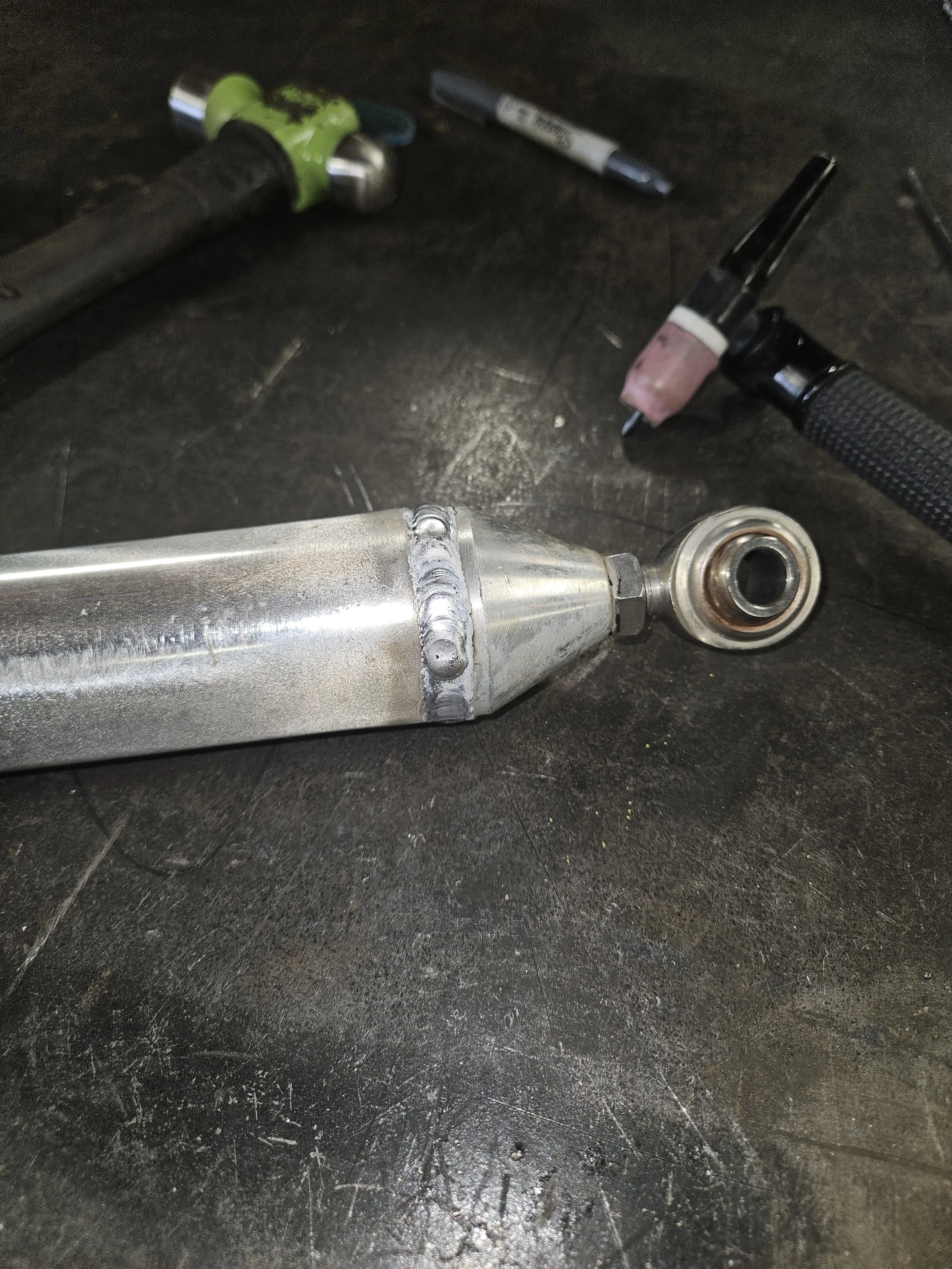 Close-up of a custom metal fitting and fabricated part being finished by an A&J Custom Metals welder.