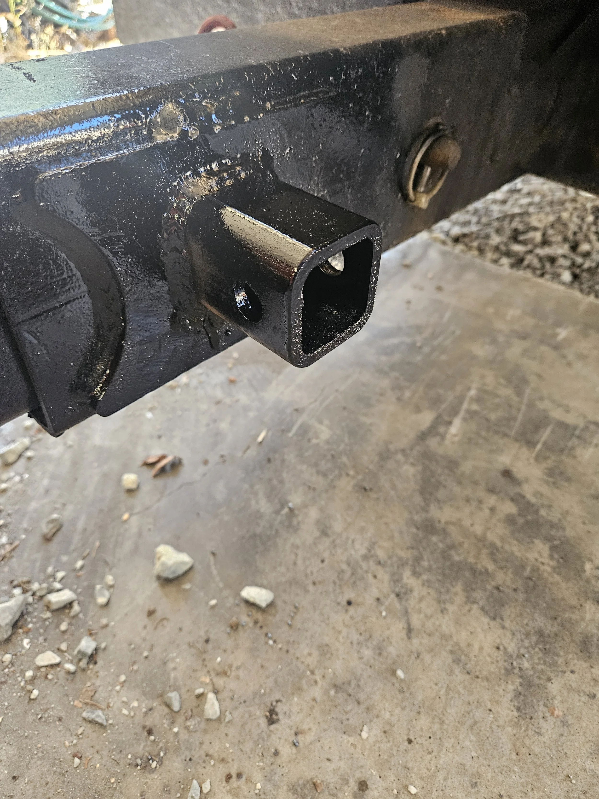 Custom black trailer hitch receiver tube welded onto a metal frame by A&J Custom Metals in Graham, WA.