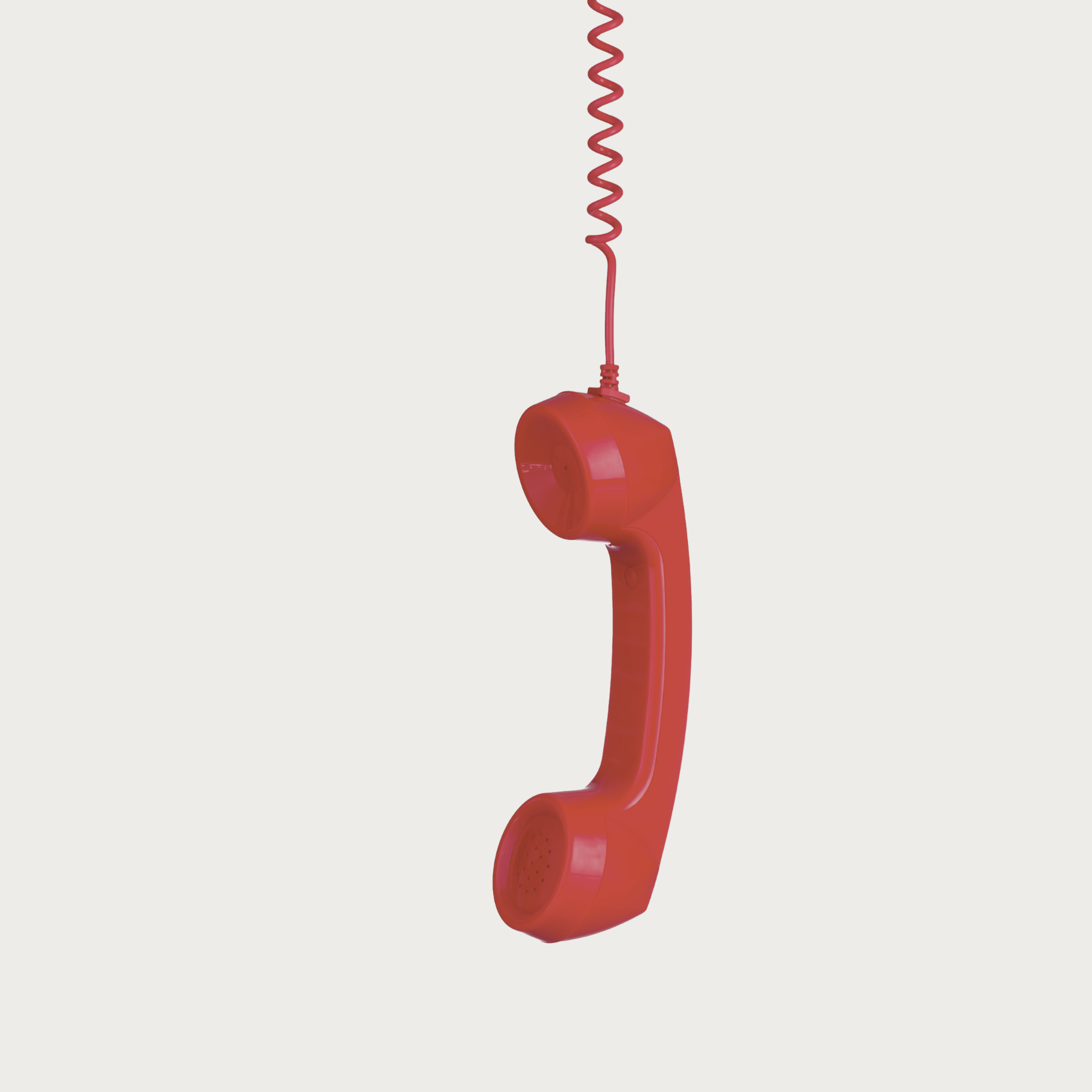 Red vintage rotary telephone hanging from a red coiled cord against a plain background.