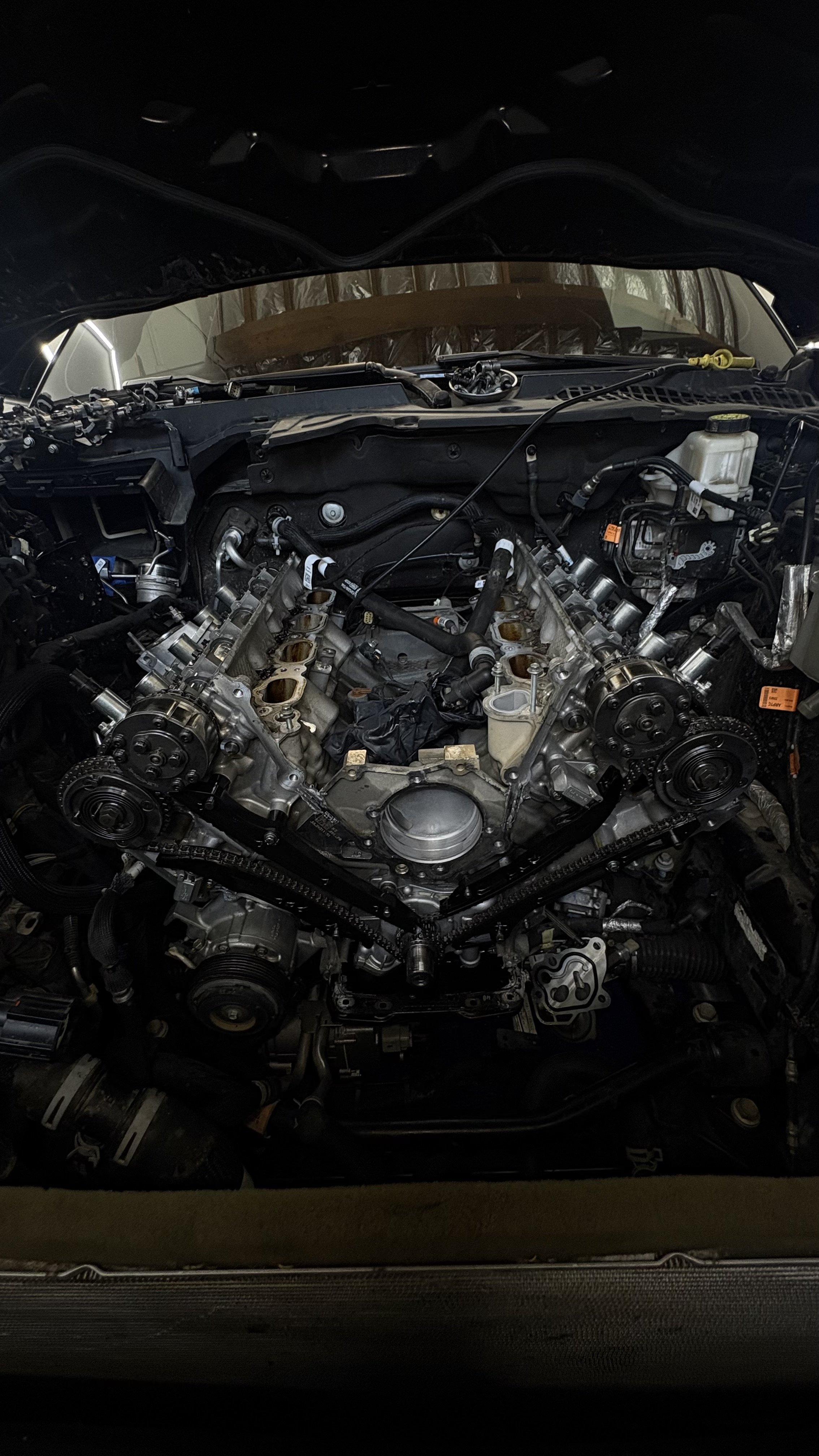 Car engine with parts removed, showing internal components and timing belt.